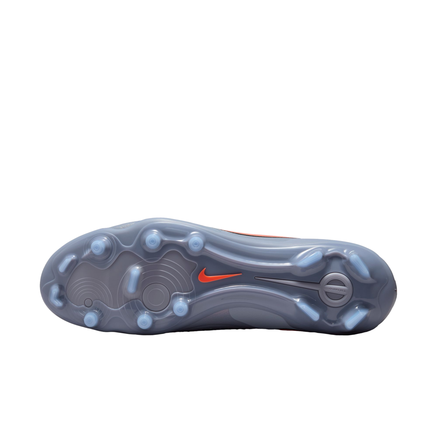 Bottom of a grey Nike soccer cleat with light blue studs and an orange swoosh on a black background. Translucent soleplate features circular traction patterns.