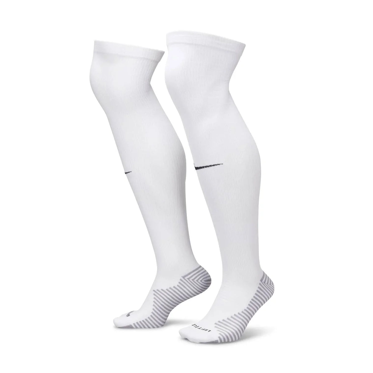 A pair of white knee-high Nike athletic socks with black swoosh logos and grey striped heel and sole patterns, displayed on a white background.