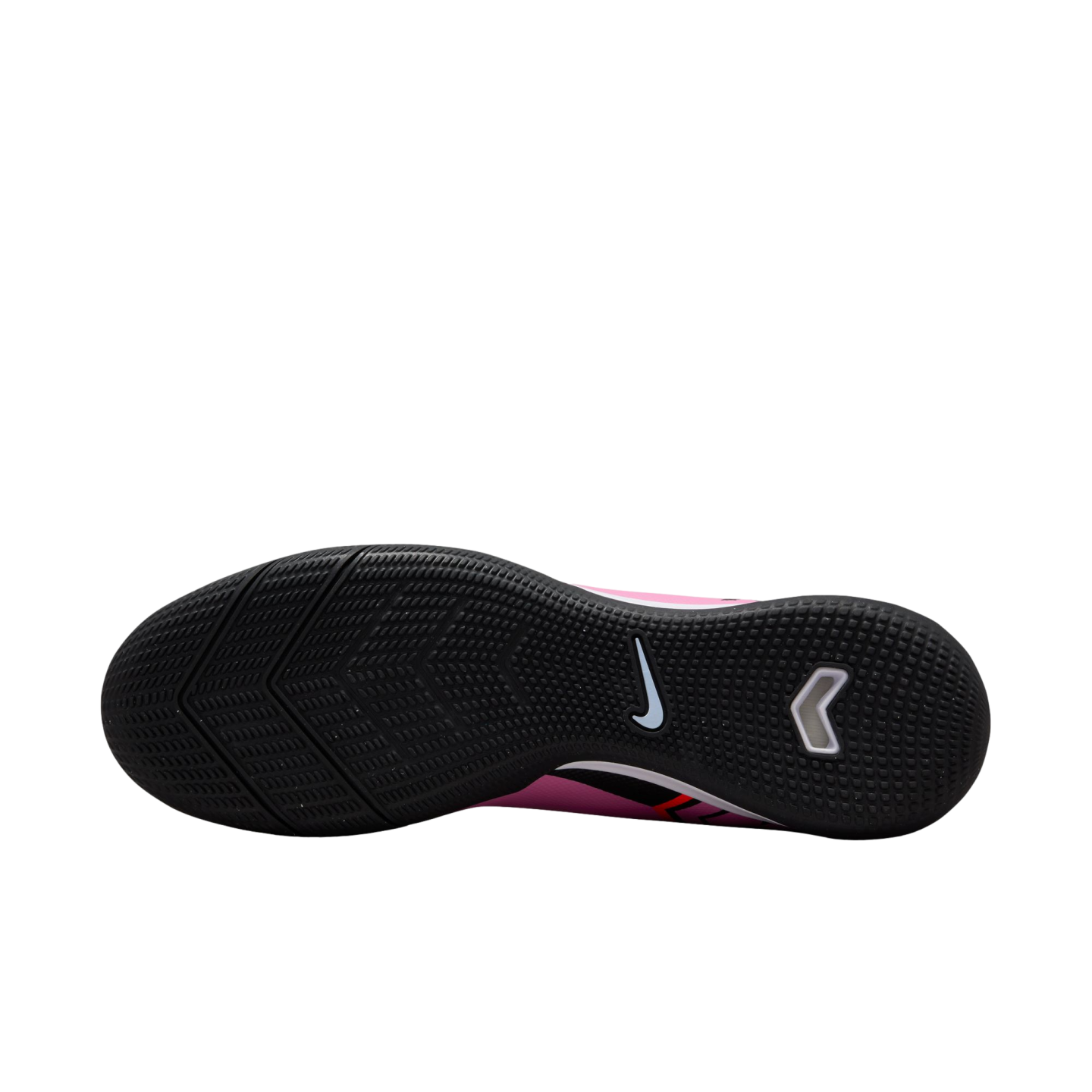 Sole view of a pink Nike indoor soccer shoe with a textured black rubber outsole and a white swoosh logo.