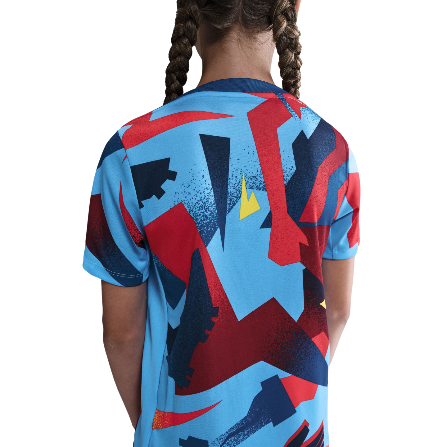 Back view of a person with braided hair wearing a light blue T-shirt with a bold geometric pattern in red, blue, and yellow.