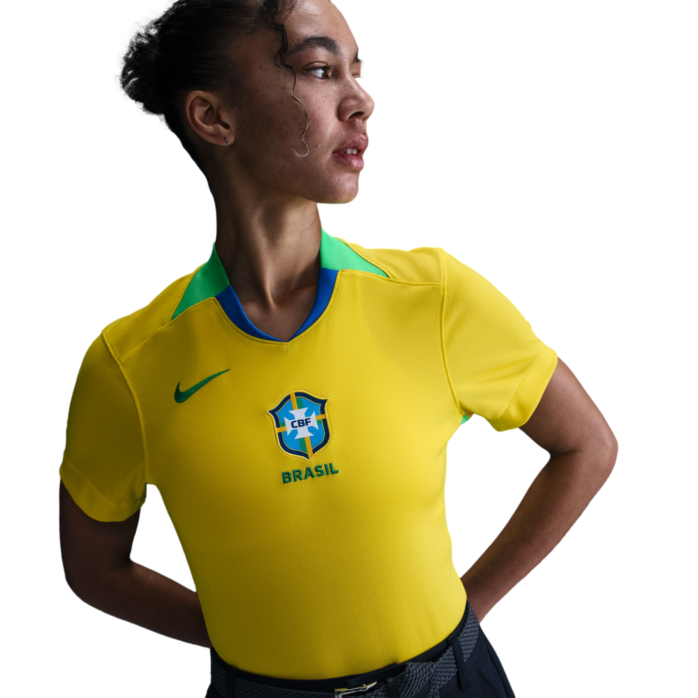 A person wearing a yellow Brazil national soccer jersey with green and blue accents, looking to the side against a plain white background.
