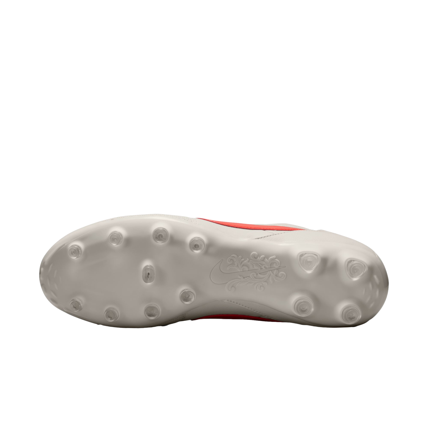 Underside of a white Nike soccer cleat showing circular studs and an ornate floral design on the sole, set against a solid black background.