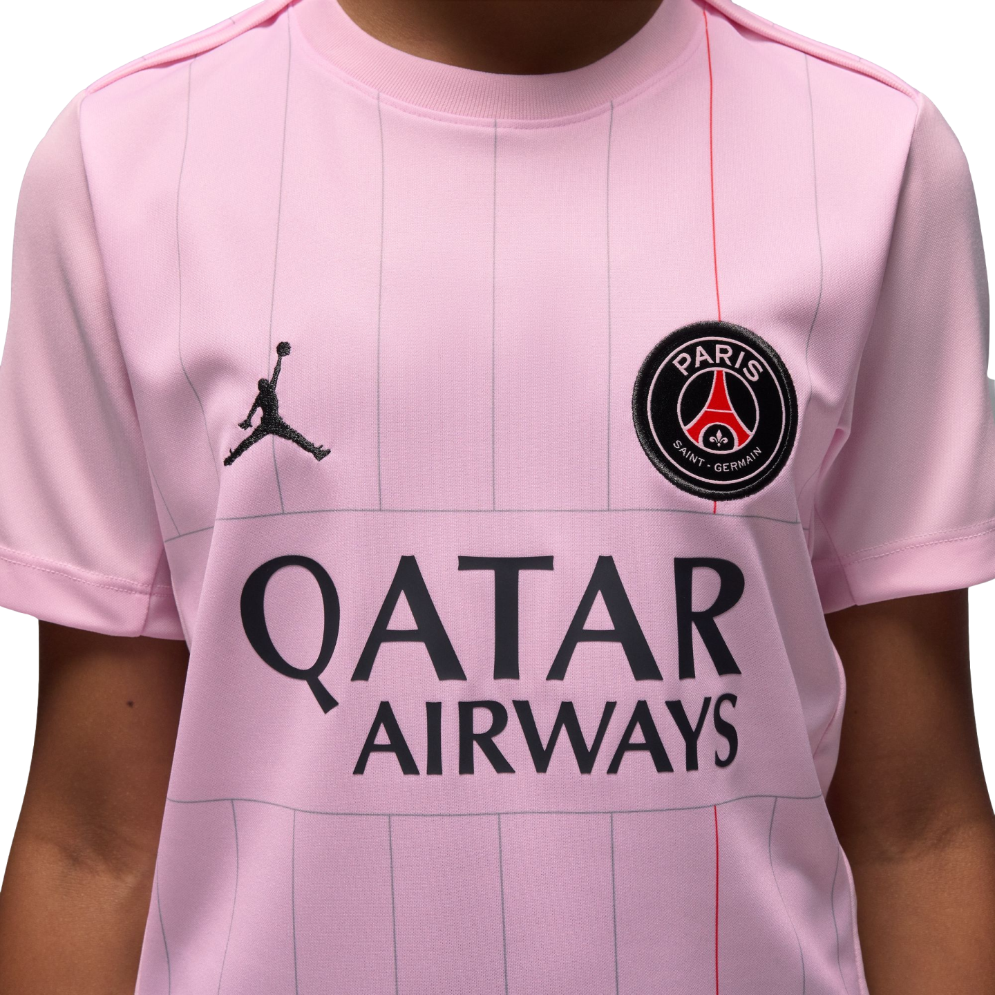 Close-up of a pink Paris Saint-Germain jersey with the Jordan Jumpman logo, the PSG club crest, and the Qatar Airways sponsor logo.