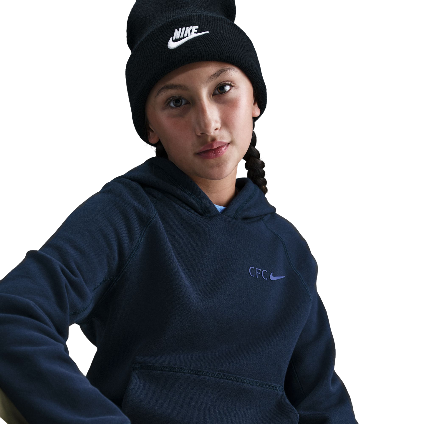 A young person wearing a black Nike beanie and a navy blue hoodie with a "CFC" Nike logo, posed against a solid black background.