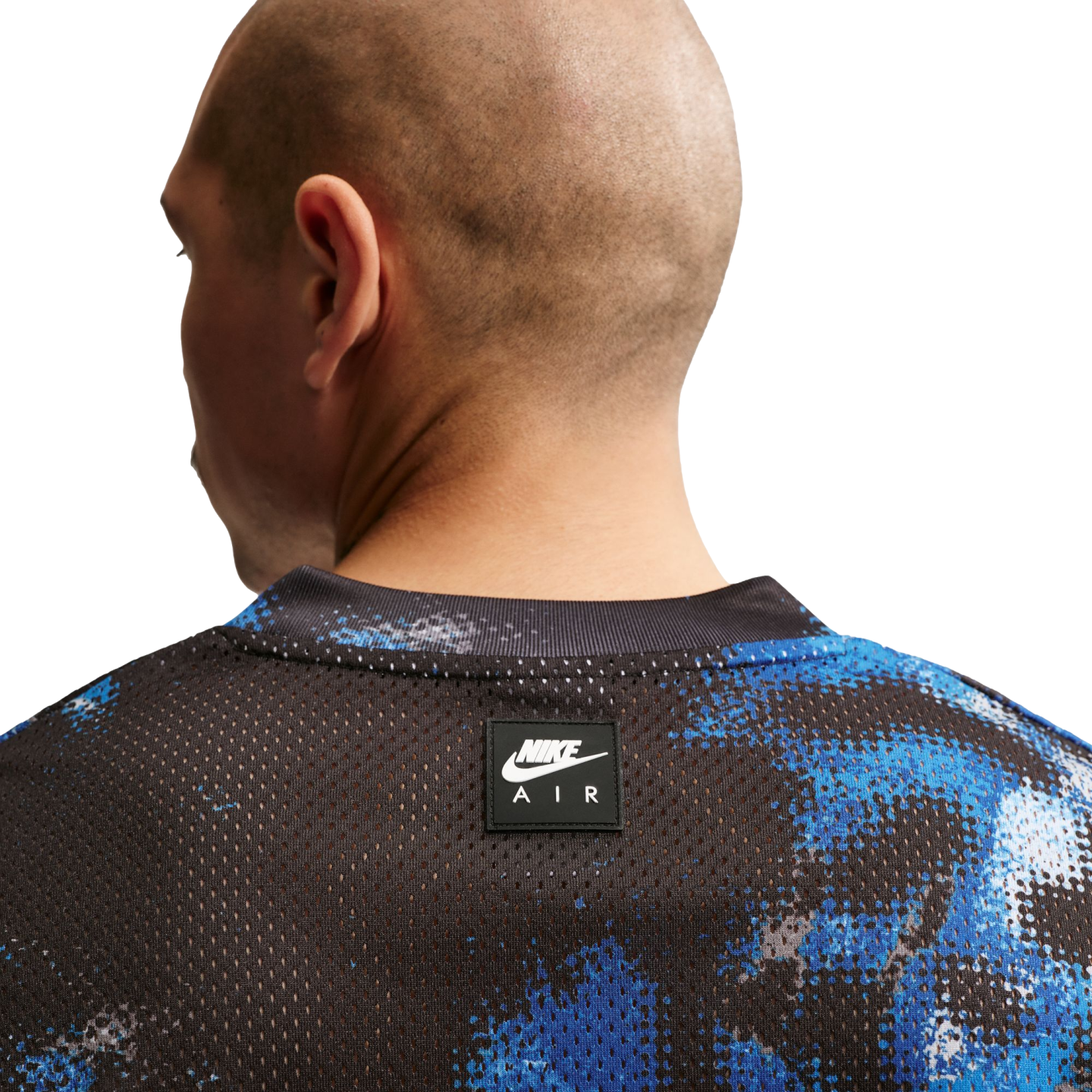 Close-up of the back of a bald man in a black and blue mesh Nike Air jersey with a small logo on the center back.