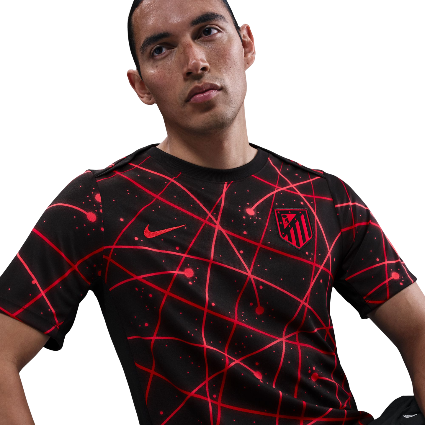A man wearing a black Nike Atlético Madrid jersey featuring an abstract red geometric line pattern.