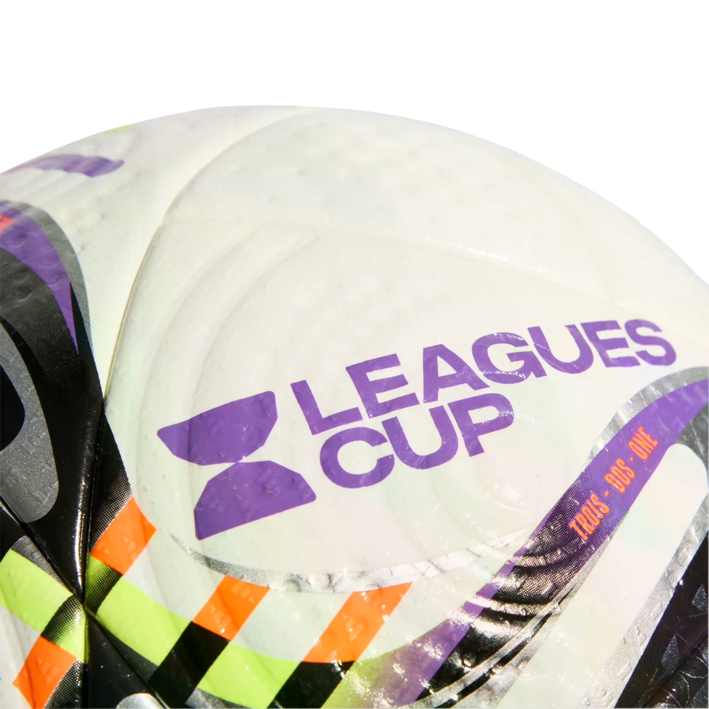 A close-up of a white soccer ball featuring the purple "LEAGUES CUP" logo and name, accented with black, green, and orange patterns on its dimpled surface.