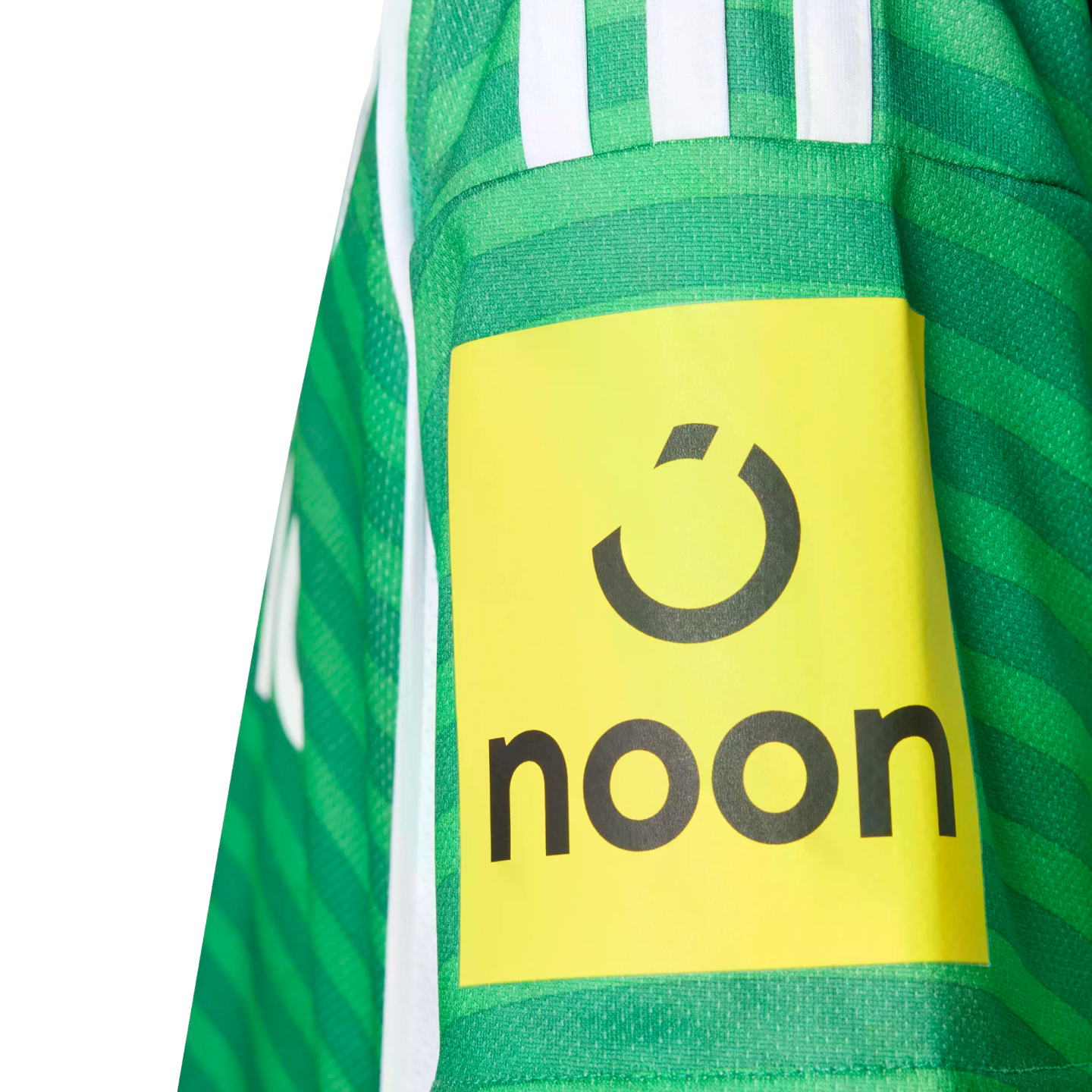 Close-up of a green striped sports jersey sleeve featuring a yellow patch with the black "noon" logo and brand icon.