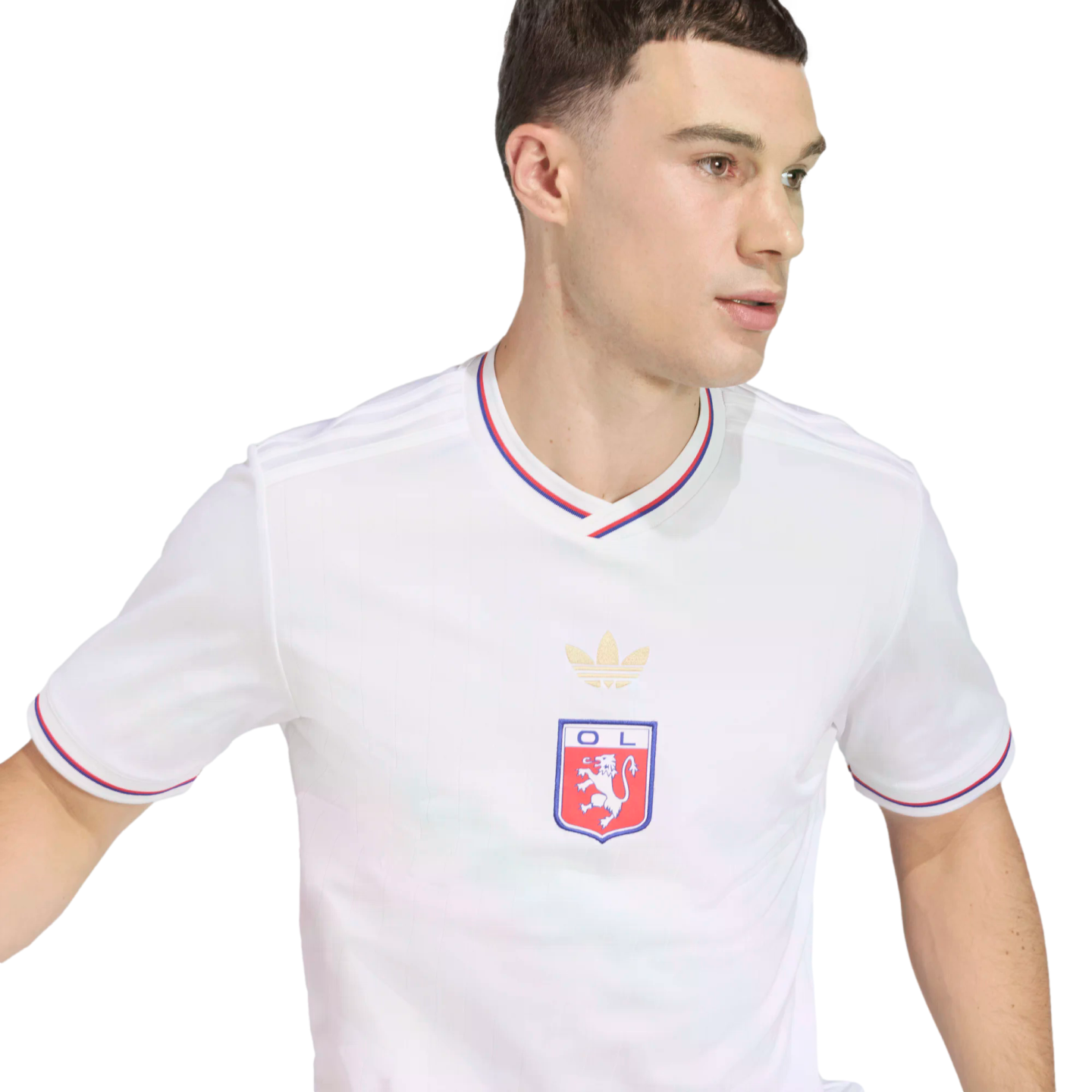 A man wearing a white Olympique Lyonnais soccer jersey with red and blue trim, looking sideways against a black background.