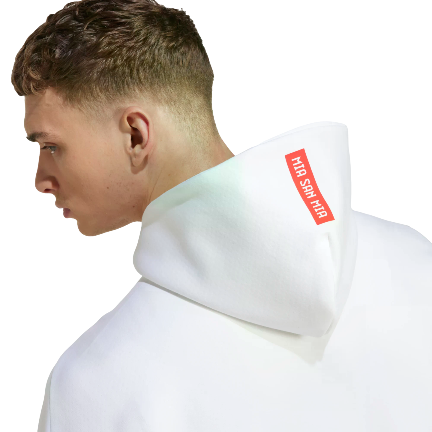 Side profile of a man wearing a white hoodie. The hood features a red rectangular patch with the white text "MIA SAN MIA".