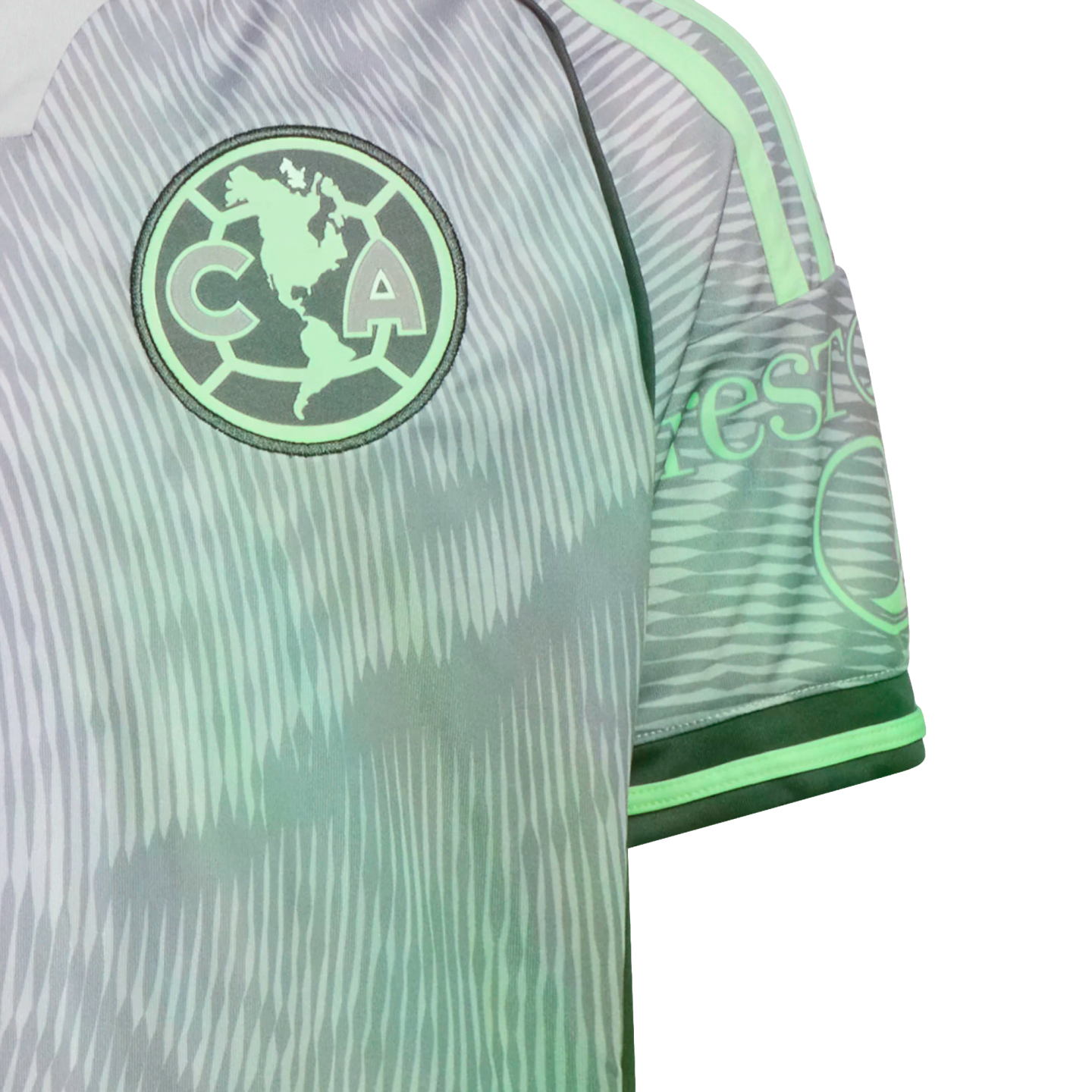 Close-up of a grey and mint green Club América soccer jersey featuring a jagged wavy pattern and the team's circular crest on the chest.