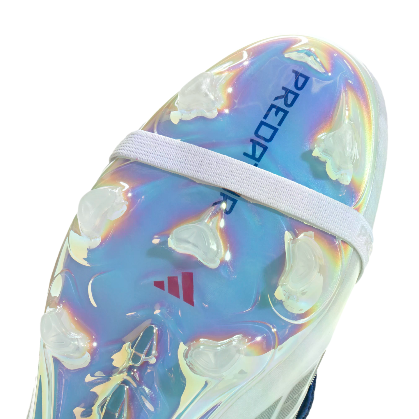 Close-up of the iridescent sole plate of an Adidas Predator soccer cleat, featuring clear studs and a white elastic strap.