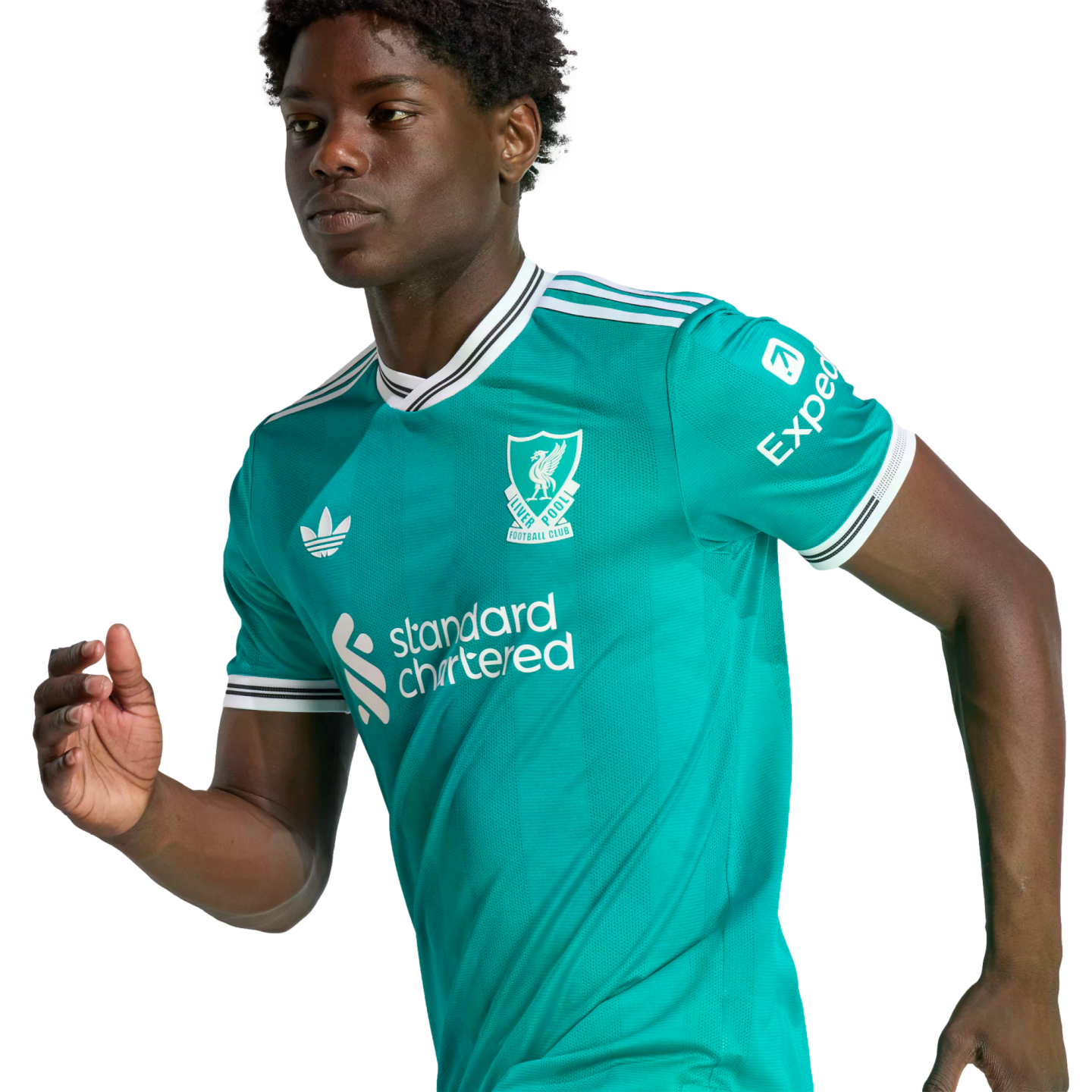 A young man in a teal Liverpool FC football jersey with white and black trim, posing in an athletic stance against a solid black background.