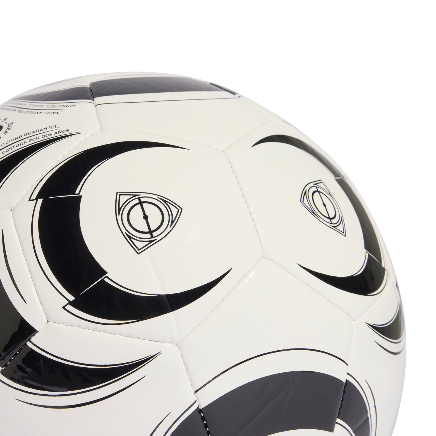 A close-up of a white soccer ball with black decorative swooshes and a triangular logo, set against a solid black background.