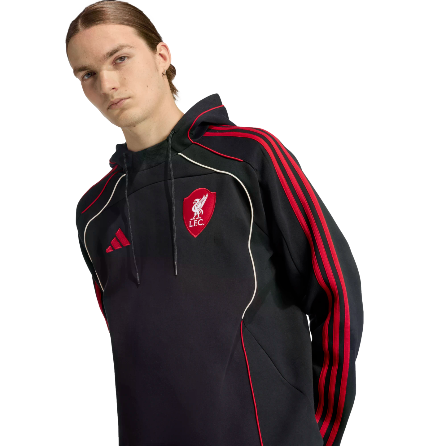 A man wearing a black Adidas hoodie with a red Liverpool F.C. crest and red stripes on the sleeves against a black background.