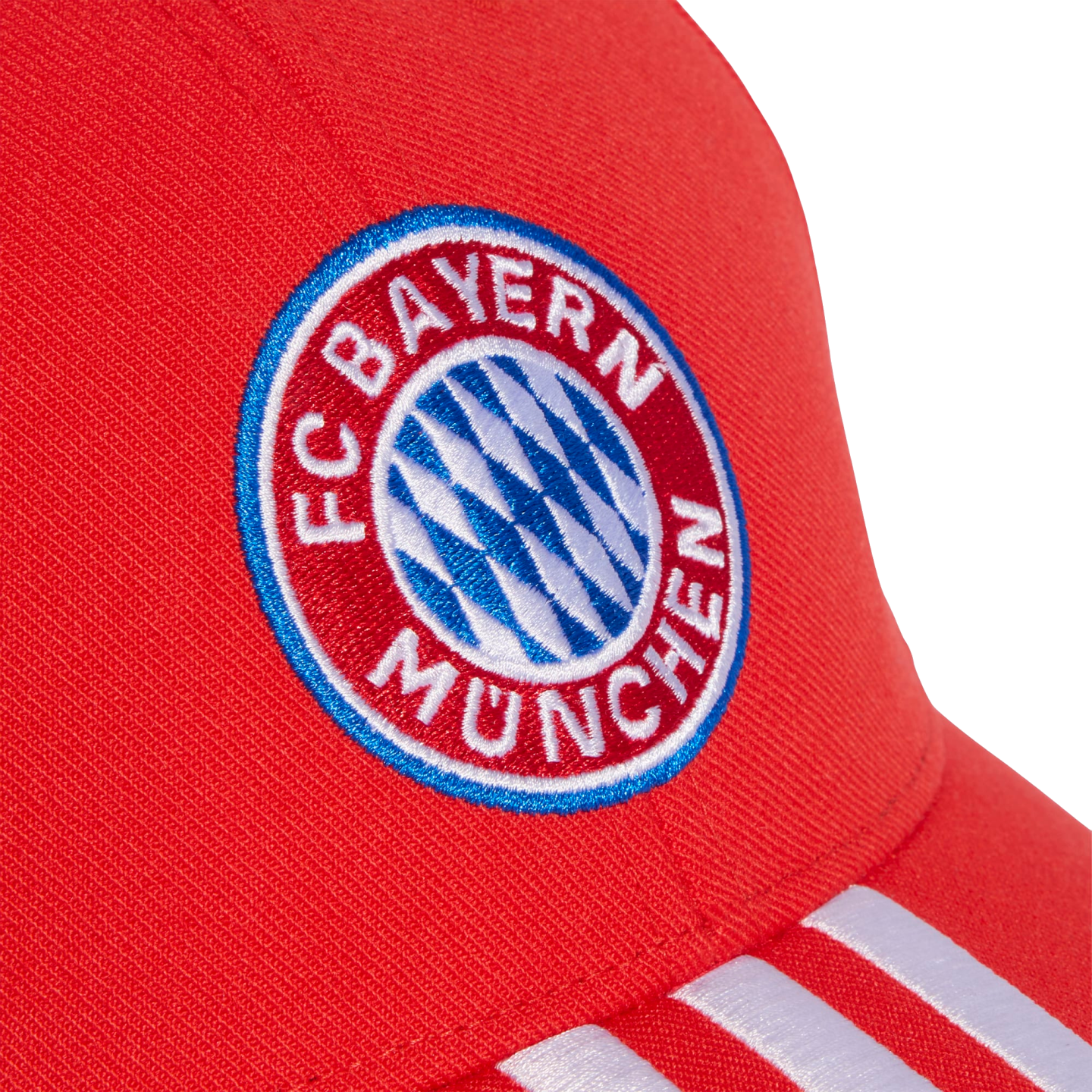 Close-up of a red baseball cap featuring the embroidered FC Bayern Munich circular crest and white stripes on the brim.