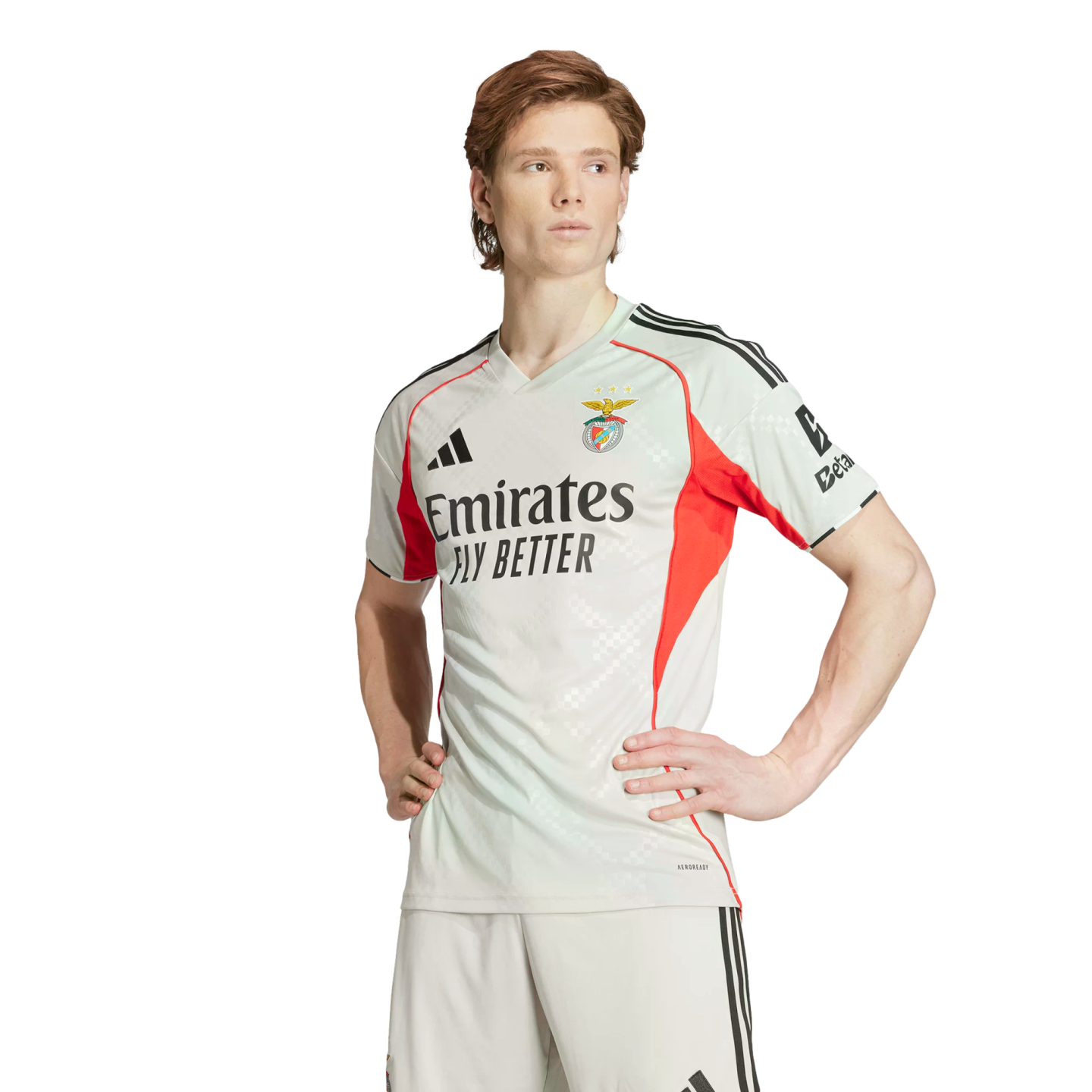 Man wearing a light grey and red SL Benfica soccer kit, standing with hands on hips against a white background.