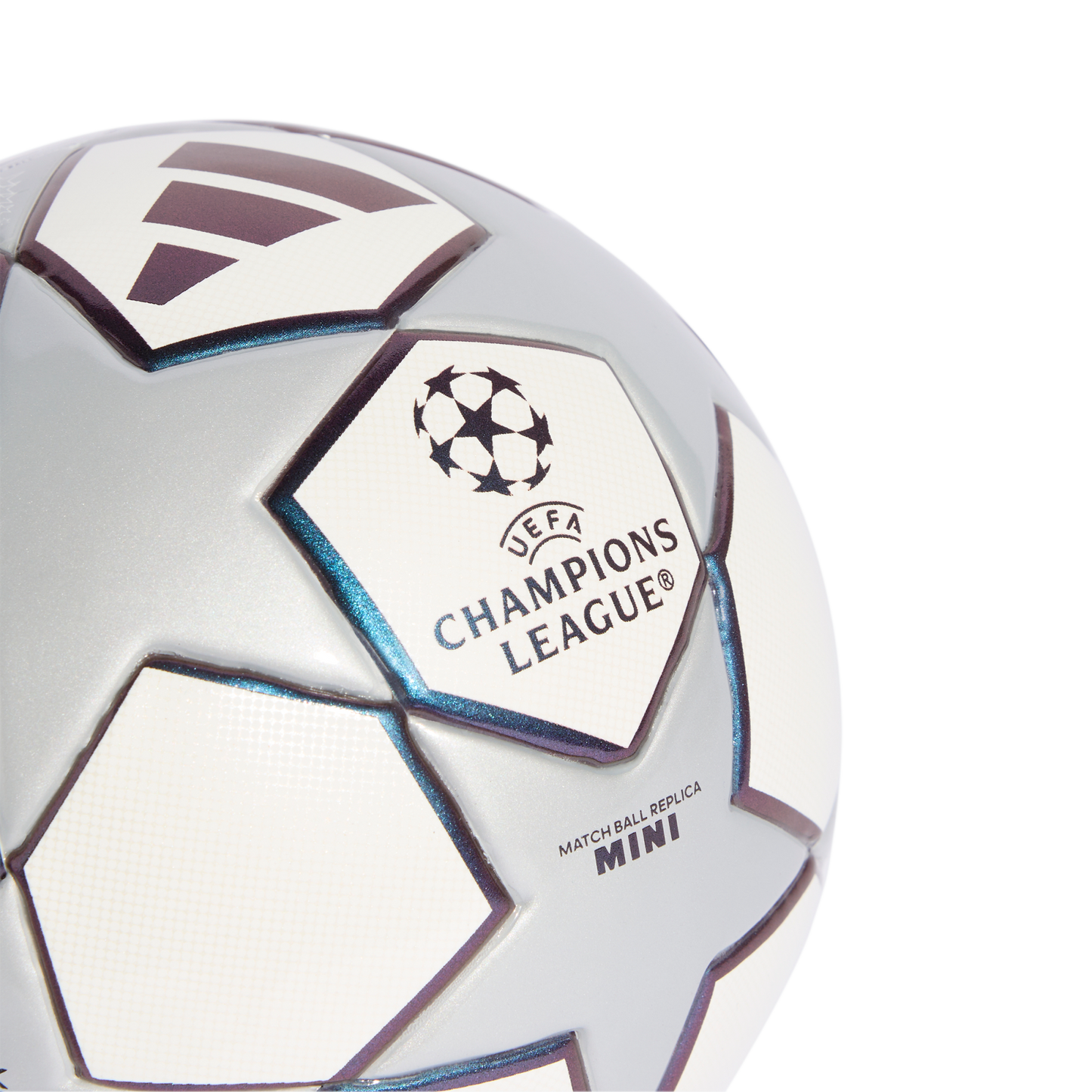 Close-up of a silver and white UEFA Champions League mini replica soccer ball with star panels and logos on a solid black background.