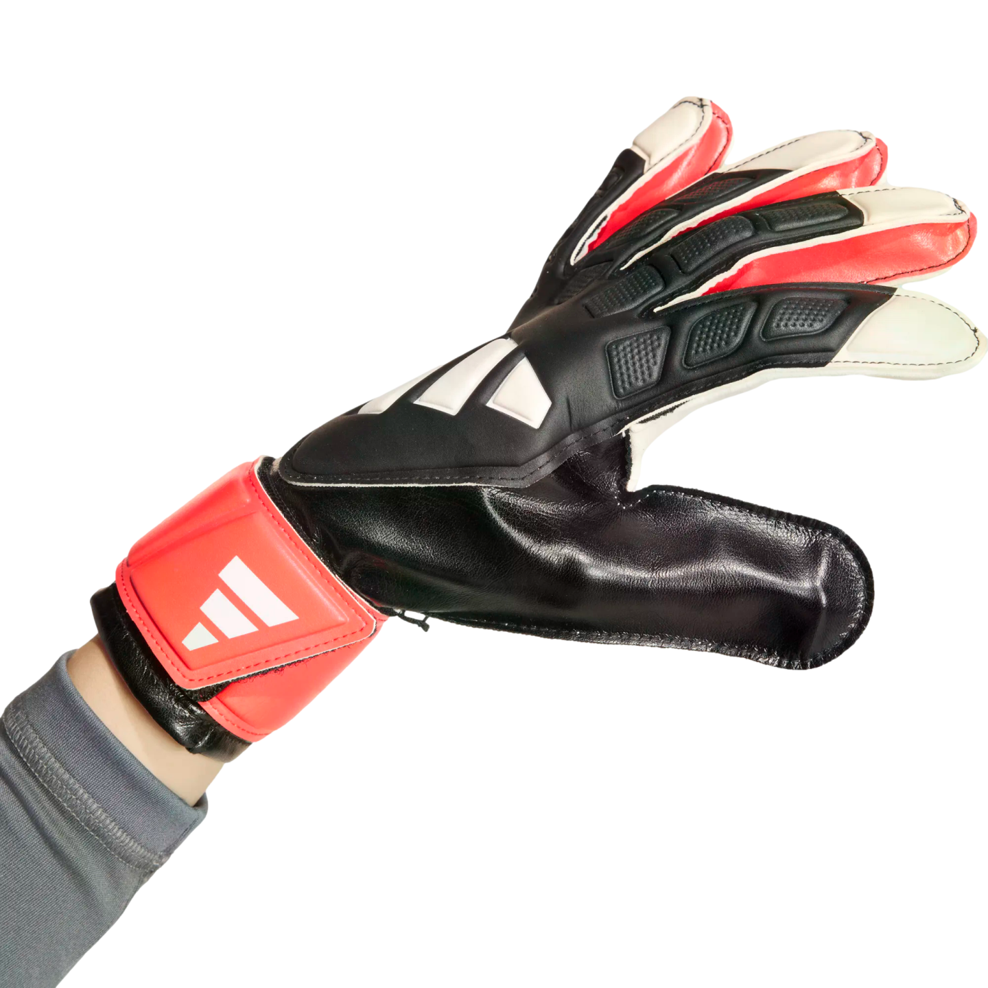 A hand wearing a black, red, and white goalkeeper glove with a red wrist strap, shown against a white background.