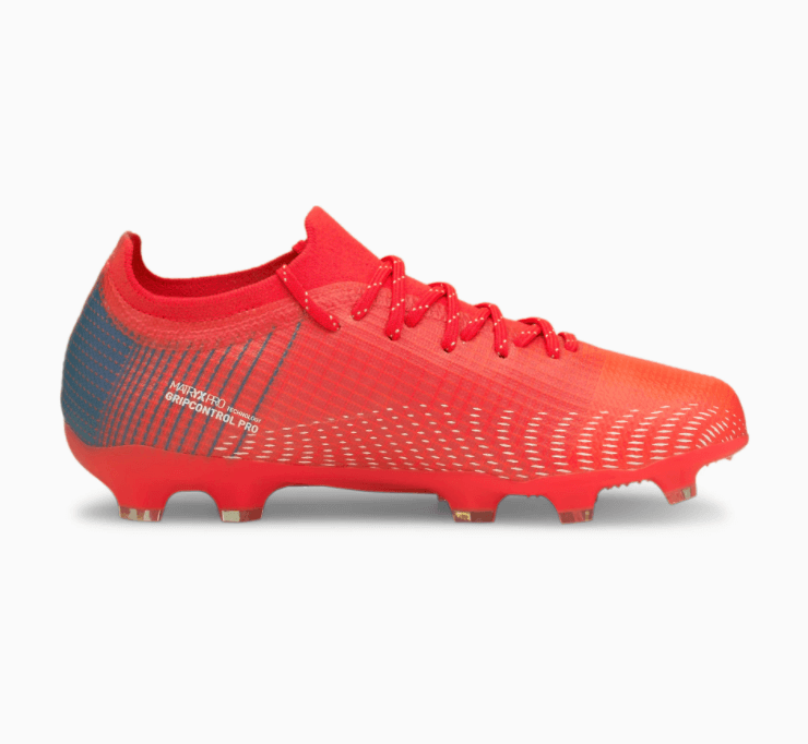 Profile of a vibrant red low-top soccer cleat featuring blue heel graphics, white textured patterns on the side, and a studded red outsole.