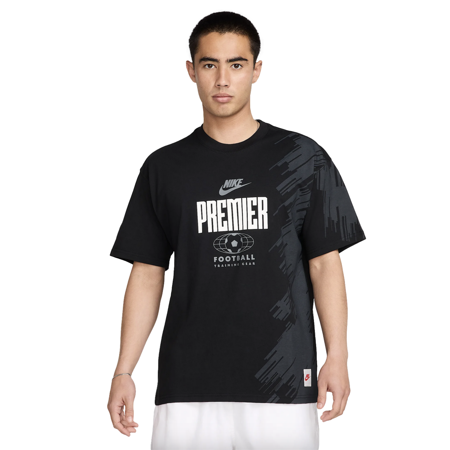 A man wearing a black Nike Premier Football graphic t-shirt and white shorts against a white background.