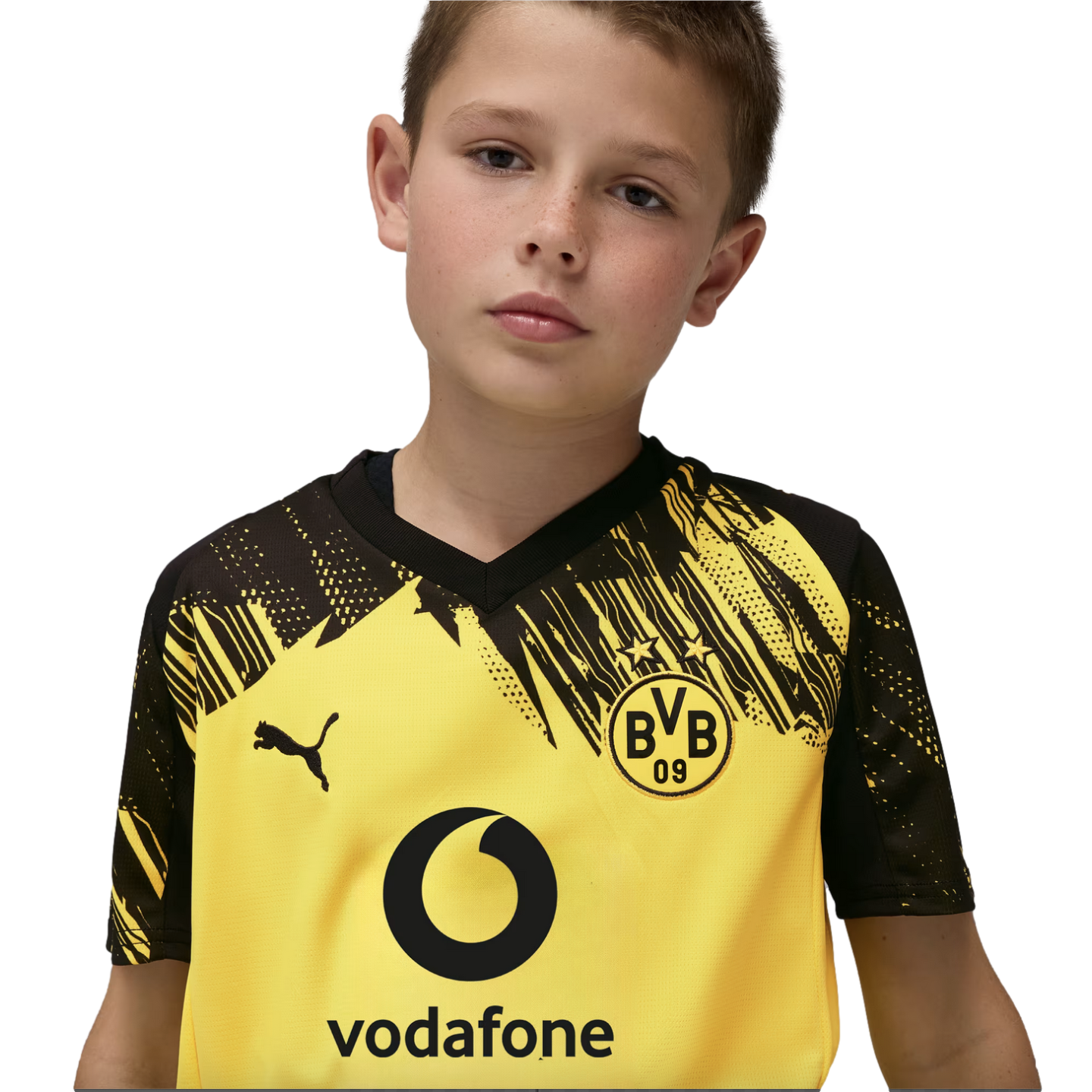 A young boy wearing a yellow and black Borussia Dortmund Puma soccer jersey with a Vodafone sponsor logo against a black background.