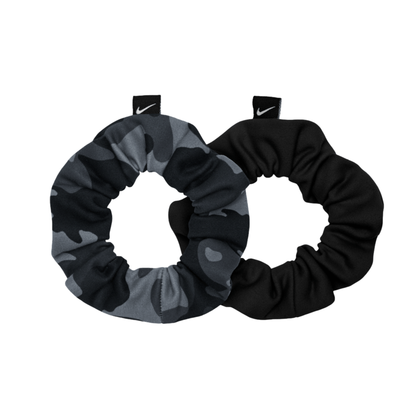 Two Nike hair scrunchies, one in grey camouflage and the other in solid black, each with a small black Nike logo tag, displayed on a black background.