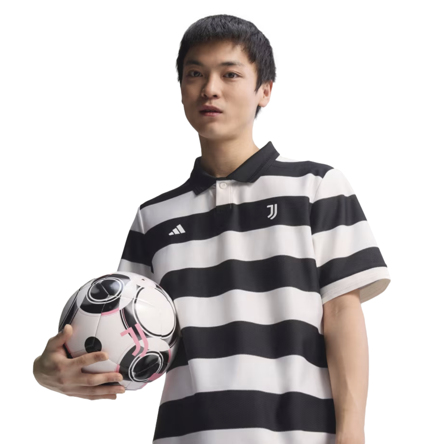 A man in a black and white striped Juventus polo shirt holding a soccer ball against a black background.