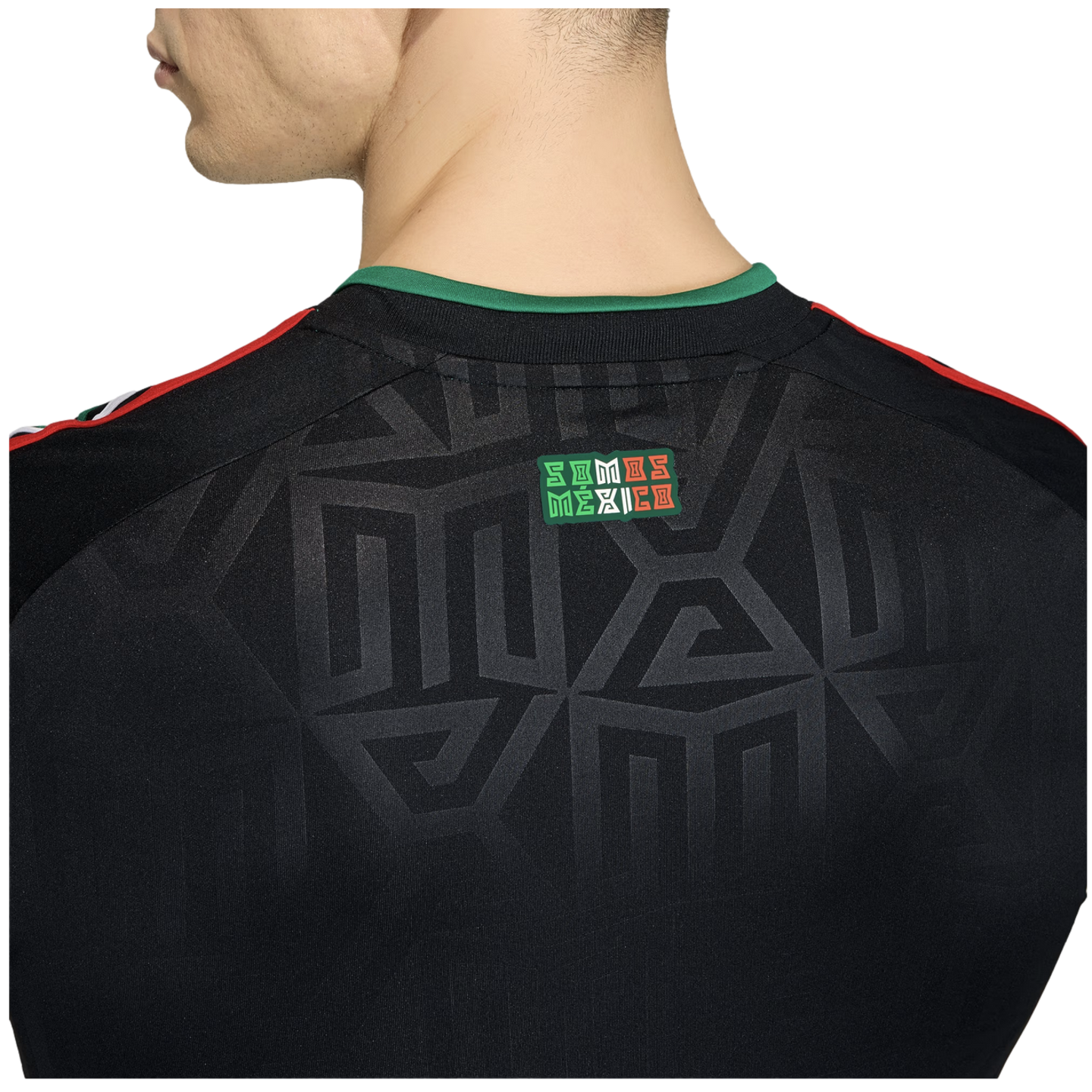 Close-up of the back of a black jersey featuring a green collar, tonal geometric patterns, and a small "SOMOS MÉXICO" patch.