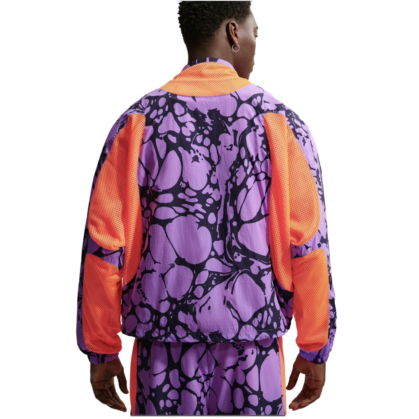 Rear view of a man wearing a purple and black abstract print jacket and shorts with vibrant orange mesh panels, against a white background.