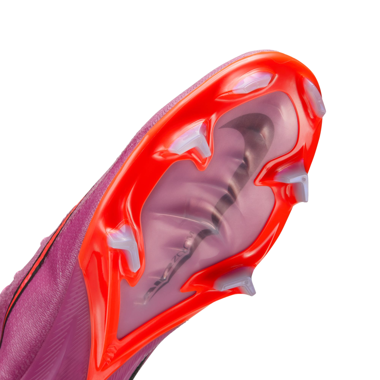 Close-up of a purple Nike soccer cleat's red and translucent sole, featuring white studs and a visible Air Zoom unit through a clear panel.