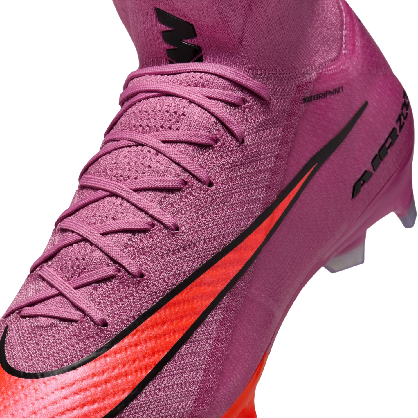 Close-up of a pink Nike soccer cleat with a textured knit upper, bright orange swoosh, and pink laces.