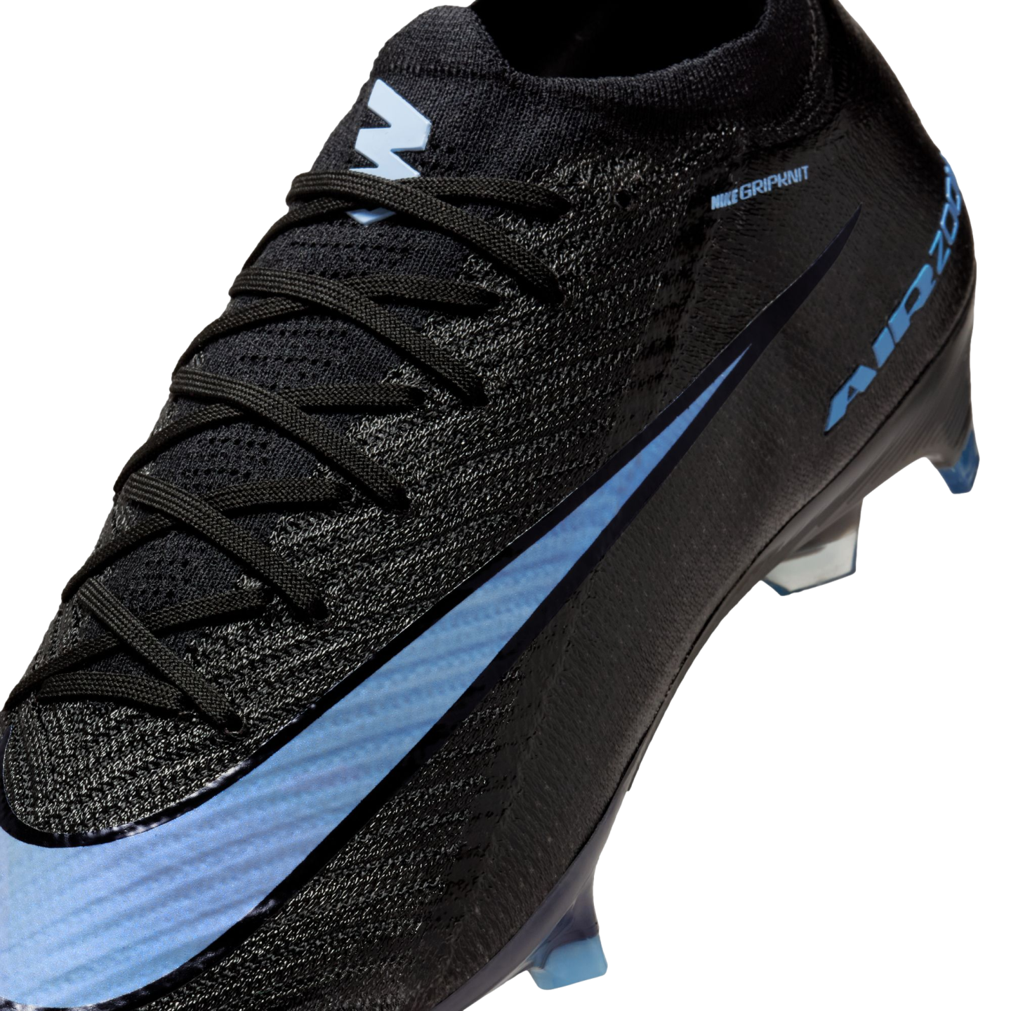 A close-up of a black Nike soccer cleat featuring a light blue swoosh, textured Gripknit upper, and light blue studs.