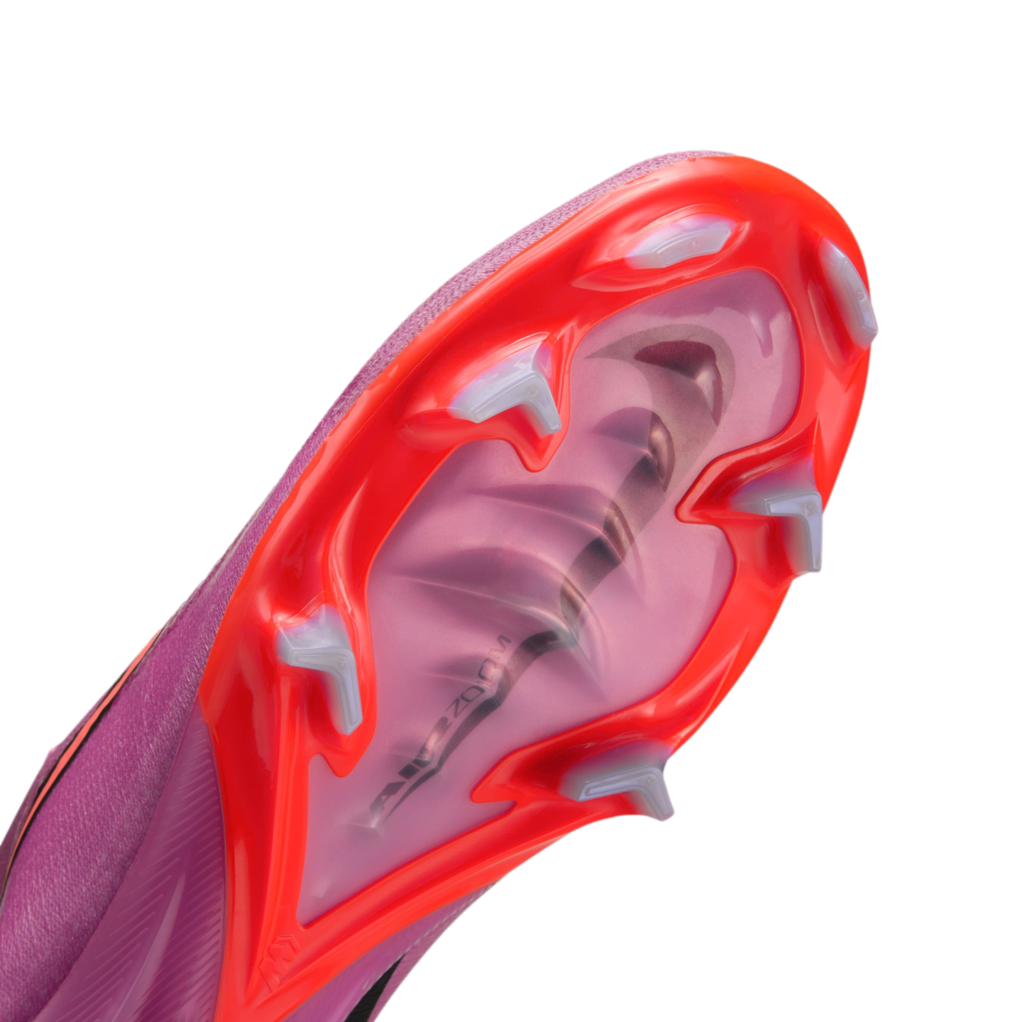Close-up of the soleplate of a pink and orange Nike soccer cleat, showing white studs and an "Air Zoom" unit visible through the translucent pink center.