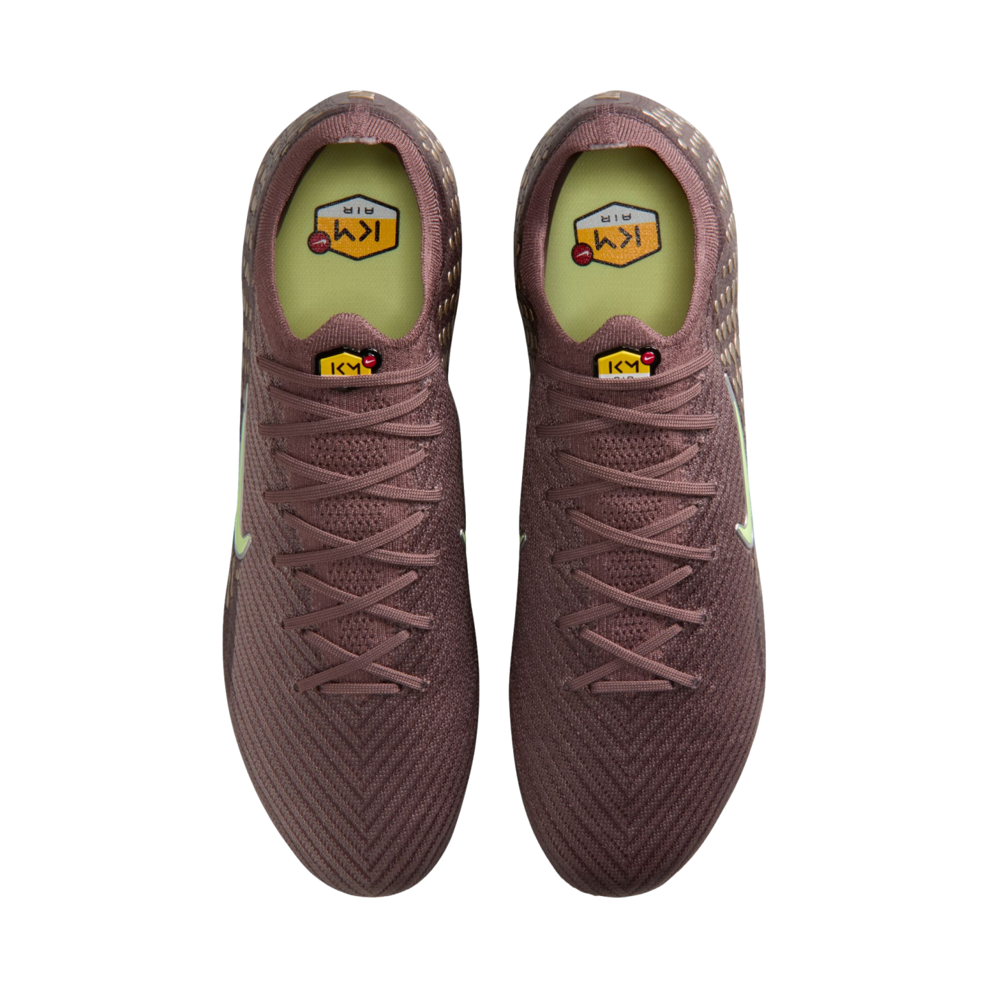 Top-down view of a pair of purple soccer cleats with yellow KM AIR logos on the tongues and insoles.