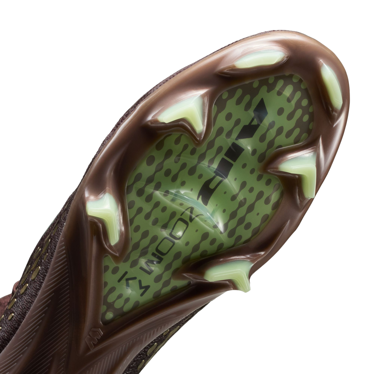 Close-up of a Nike soccer cleat's soleplate with a brown frame, light green triangular studs, and a translucent green center showing "AIR ZOOM" branding and a dotted pattern.