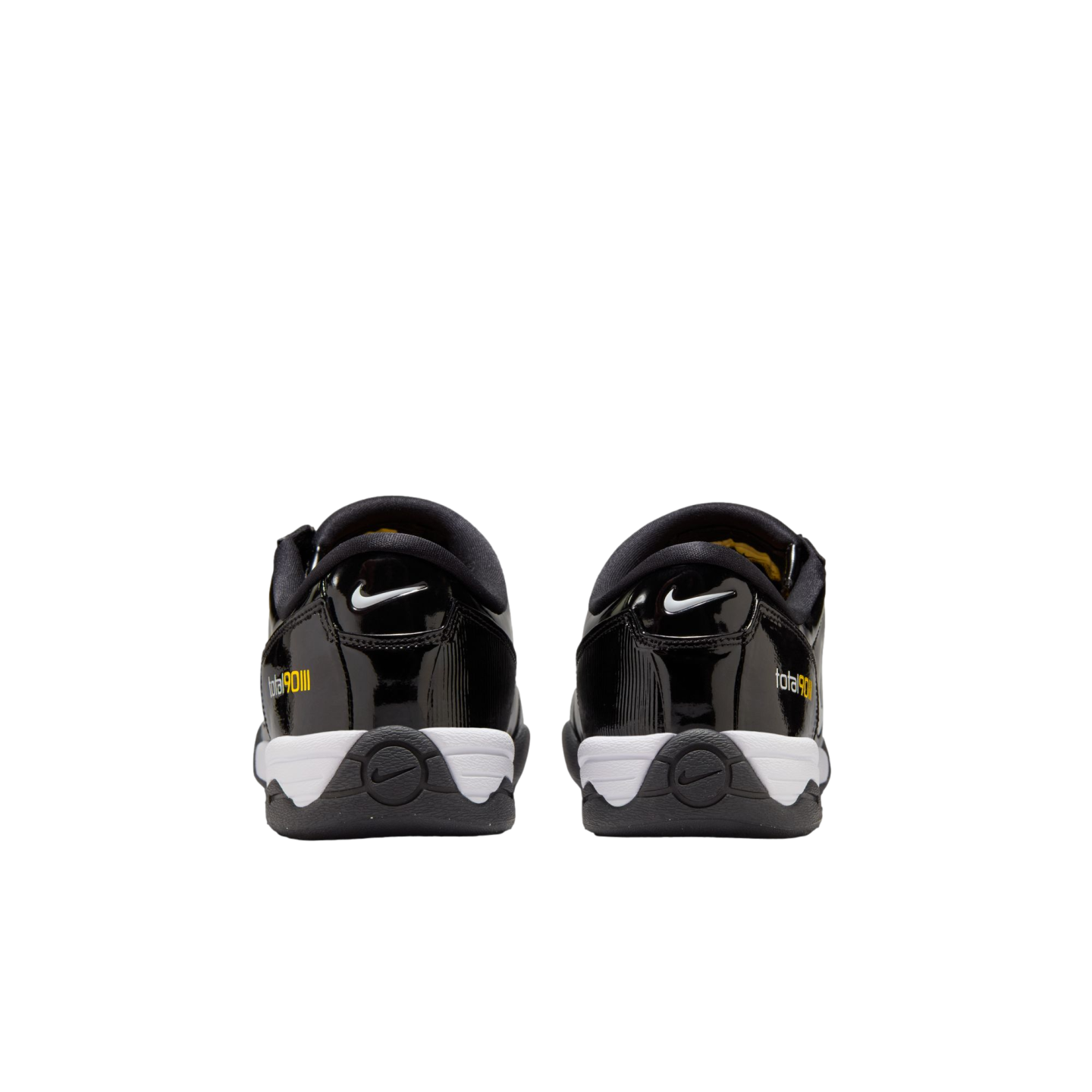 Rear view of black Nike Total 90 III sneakers with white midsoles and yellow branding against a white background.