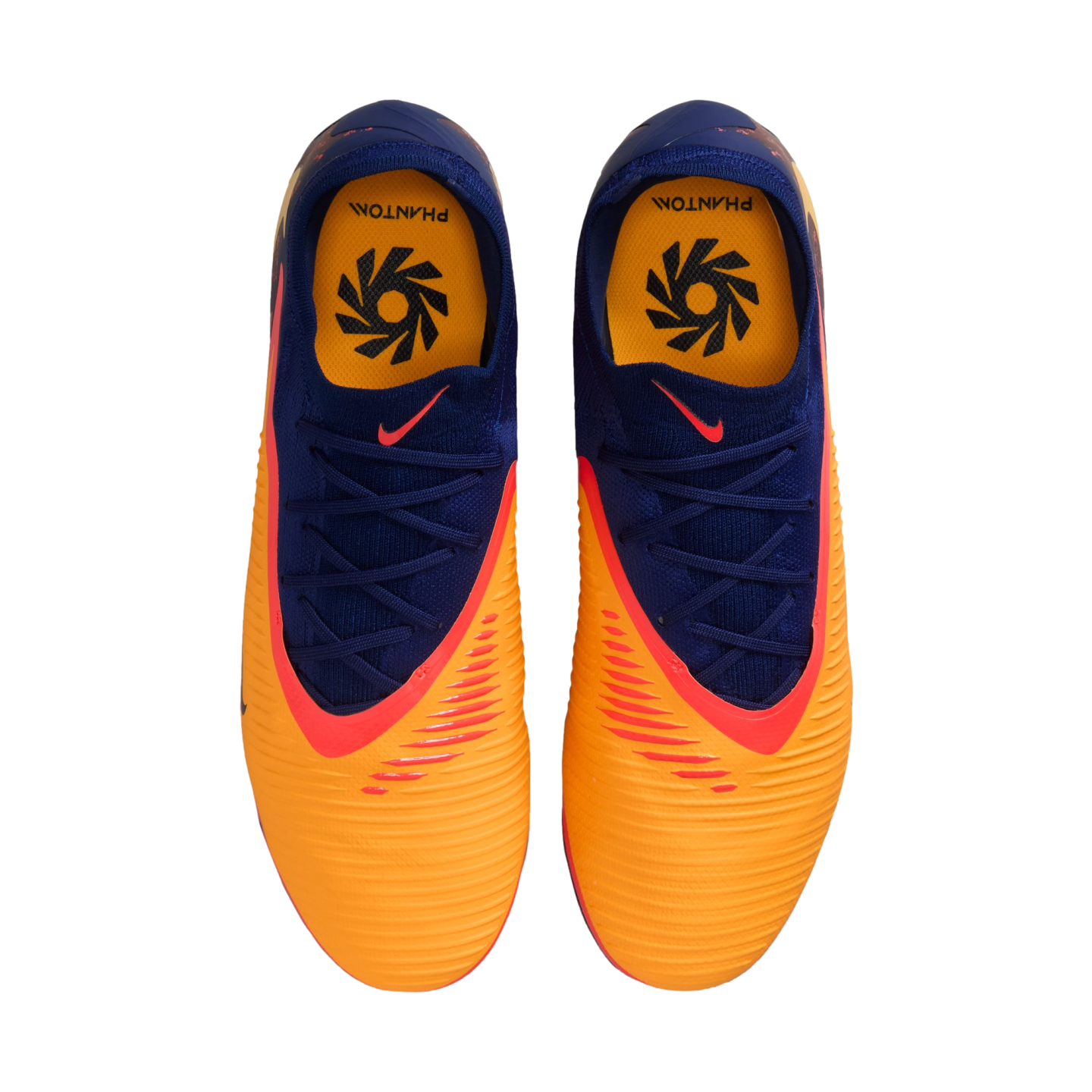 Top-down view of orange and navy blue Nike Phantom soccer cleats with red accents, displayed on a black background.