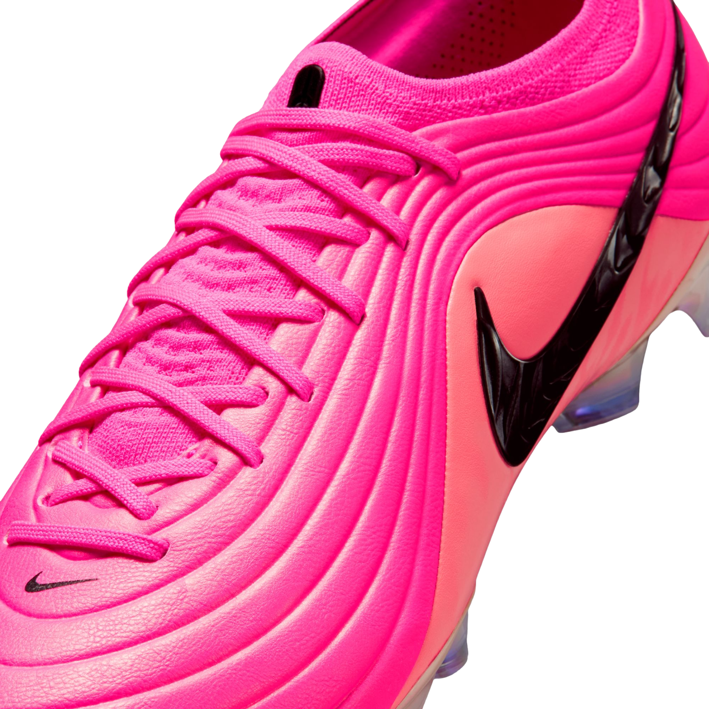 A vibrant pink Nike soccer cleat with a textured, ribbed upper, matching pink laces, and a prominent black swoosh logo on a plain white background.