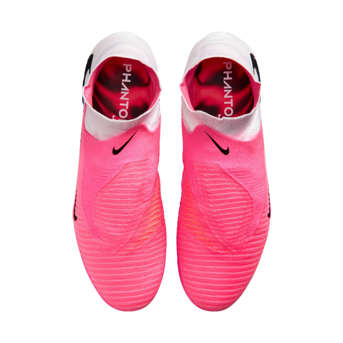 Top-down view of pink Nike Phantom soccer boots with white collars and black swooshes. The pink insoles feature the word "PHANTO" in white text.
