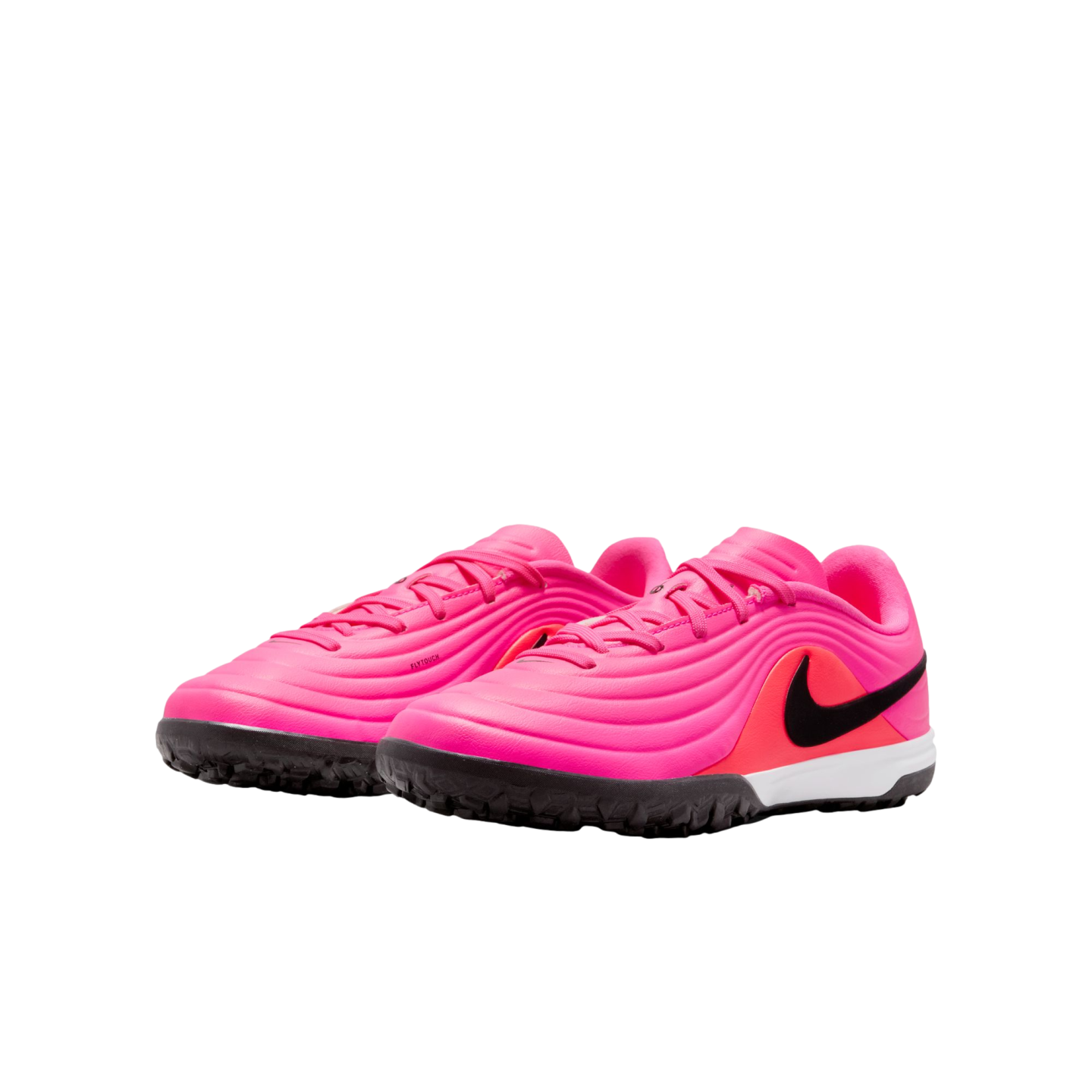 A pair of vibrant pink Nike turf soccer shoes with a black swoosh and textured upper, set against a plain white background.