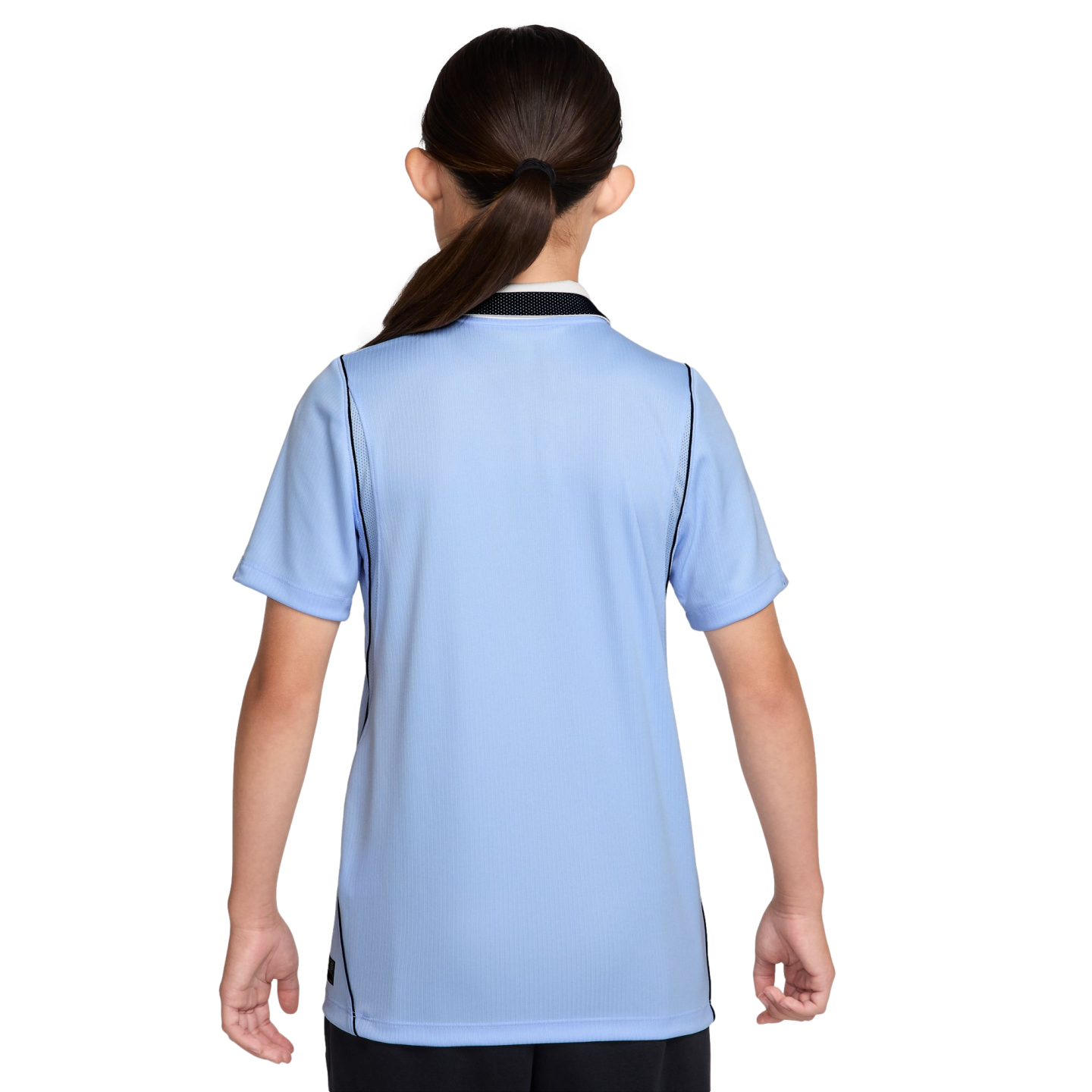Back view of a person with dark hair in a ponytail wearing a light blue short-sleeved athletic shirt with black trim against a black background.