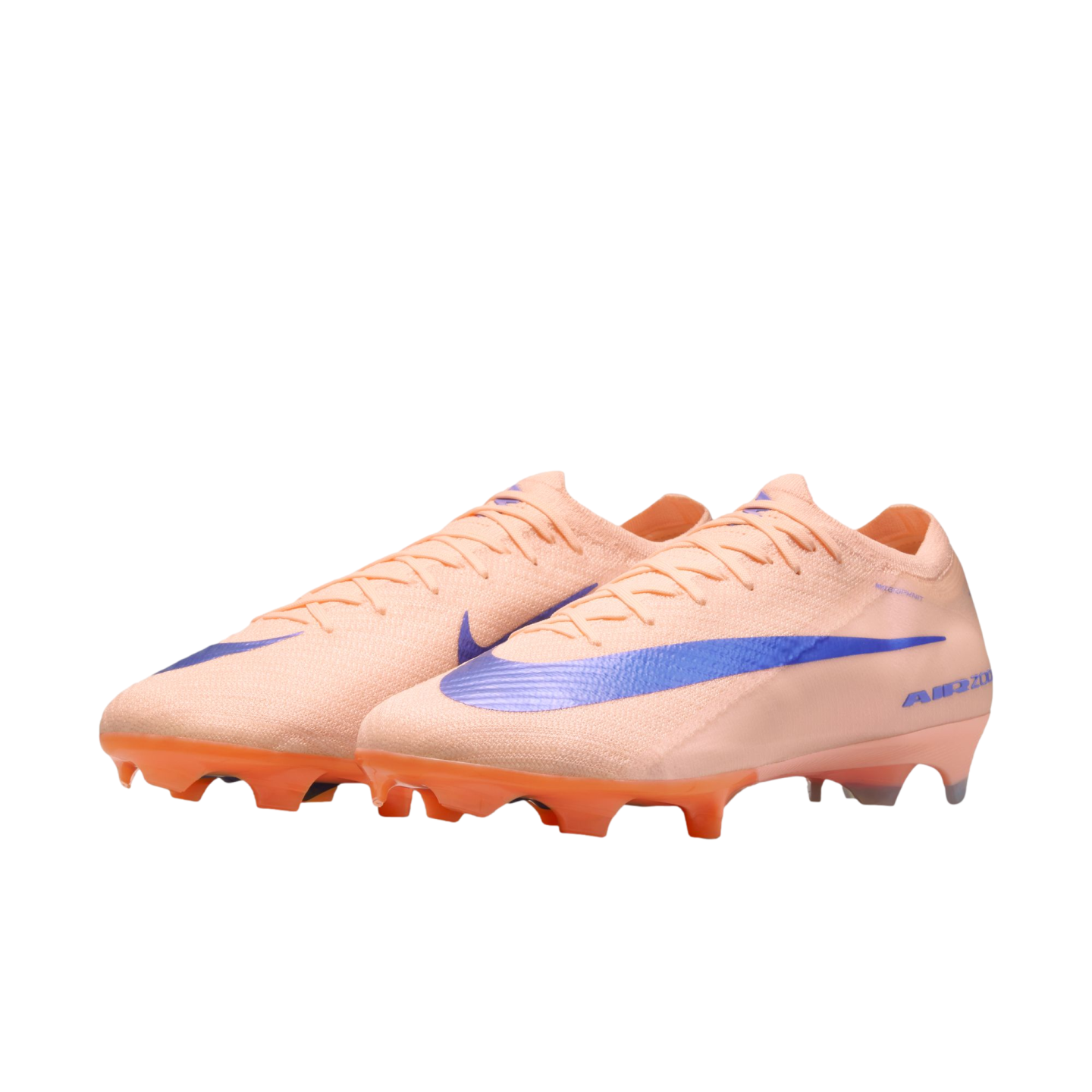 Peach-colored Nike soccer cleats with a large iridescent blue swoosh and orange studs, set against a black background.