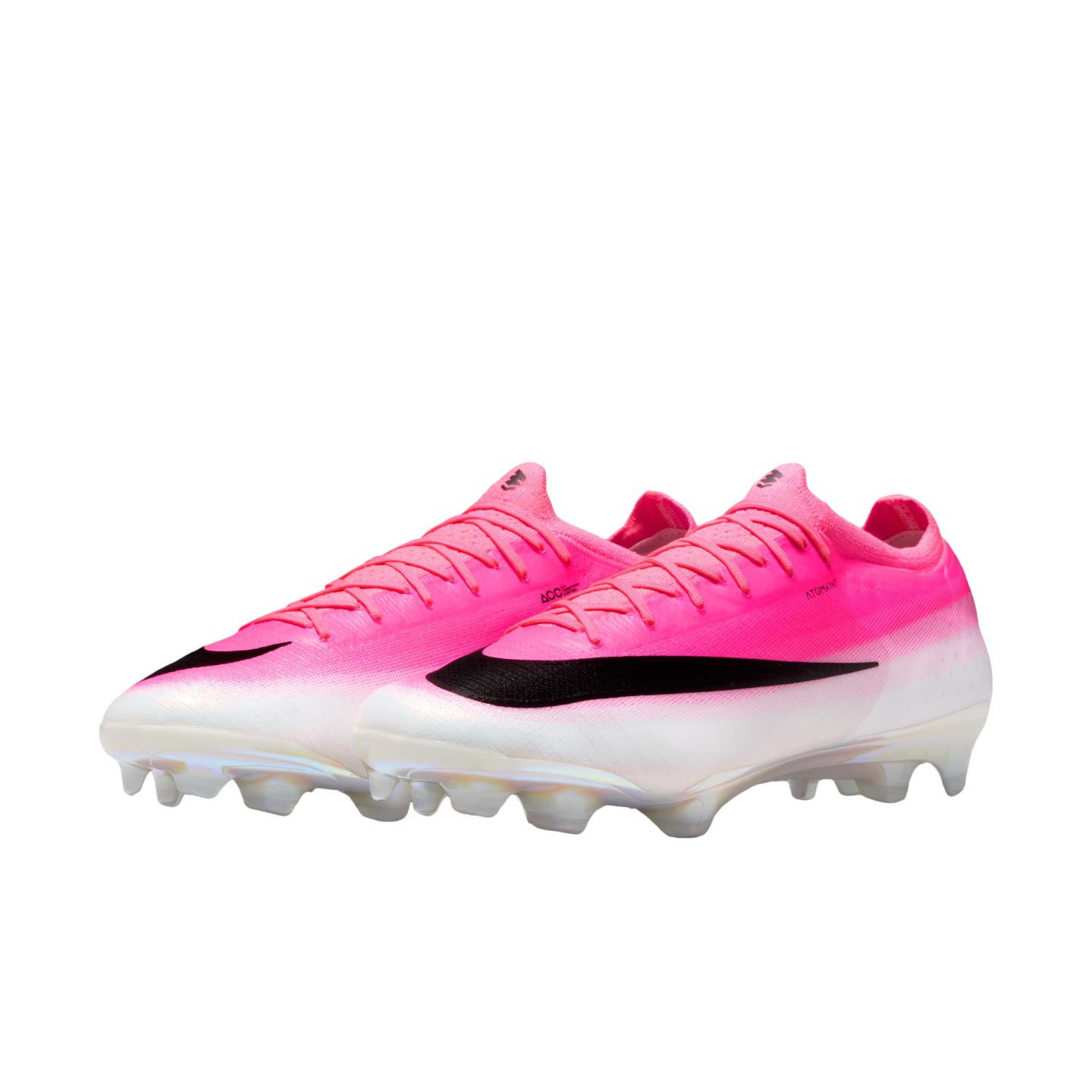 A pair of pink and white Nike soccer cleats featuring a large black swoosh and clear studs, shown against a plain white background.