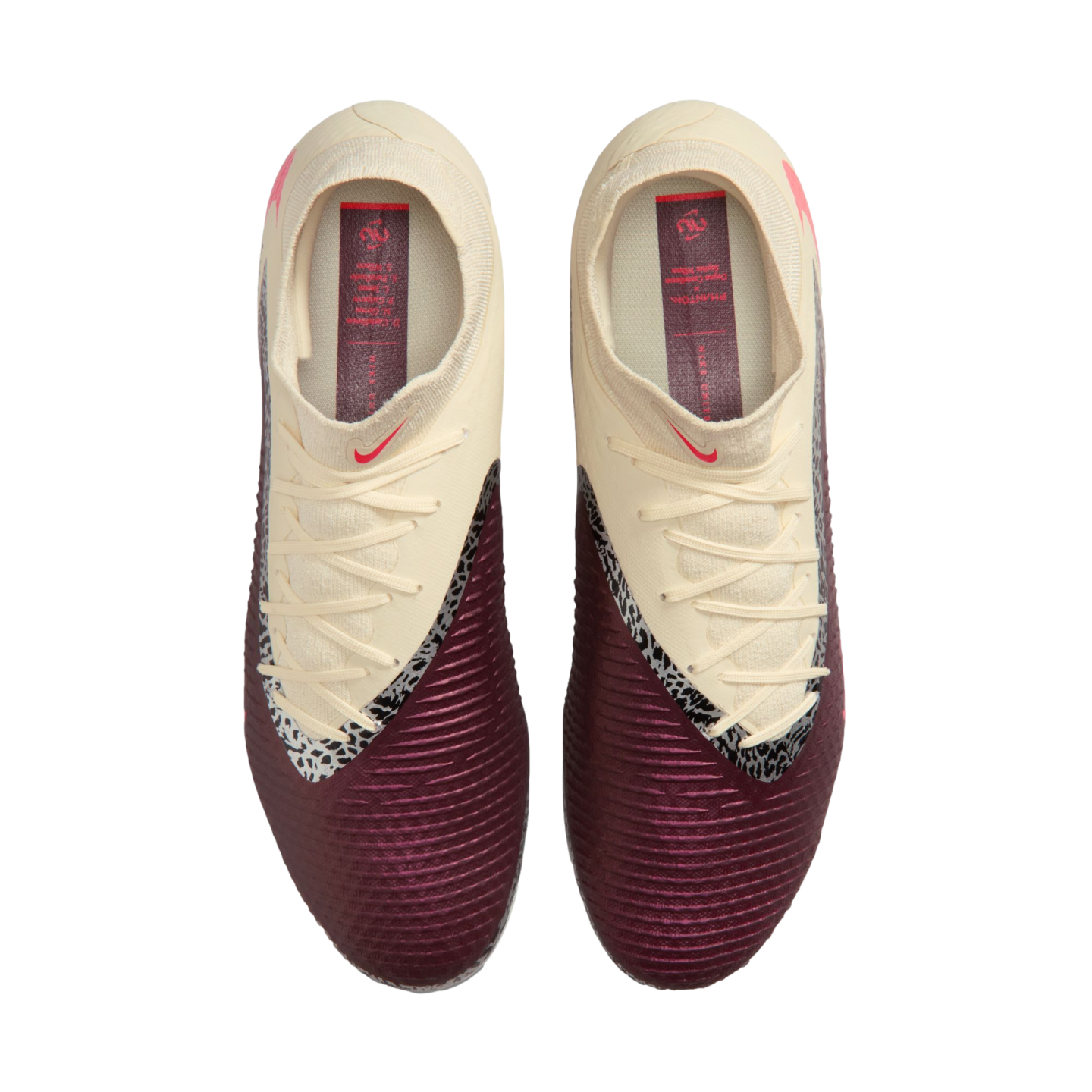 Top-down view of cream and maroon Nike soccer cleats with a textured surface and black-and-white accents, set against a black background.