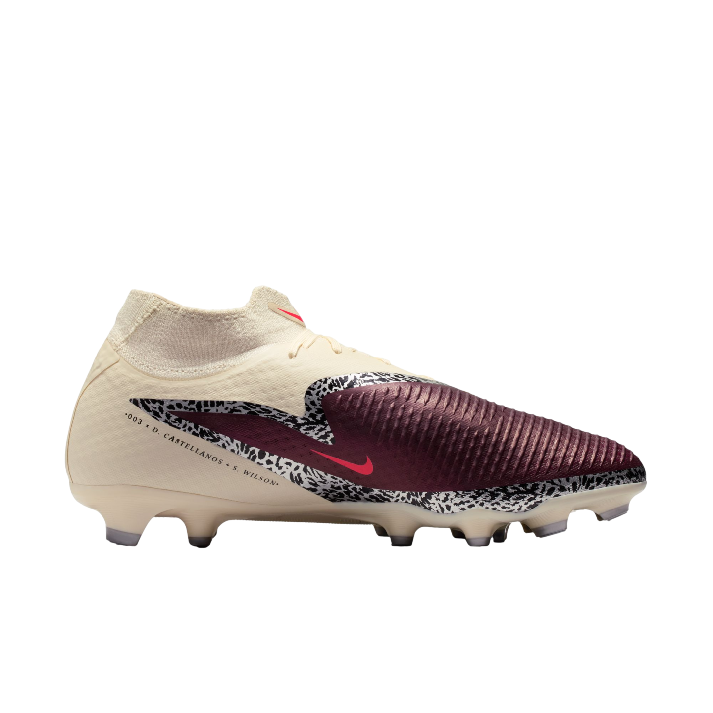 A cream and maroon Nike soccer cleat with black-and-white safari-print accents and a red Nike logo. The side features text: "003 x D. CASTELLANOS + S. WILSON".