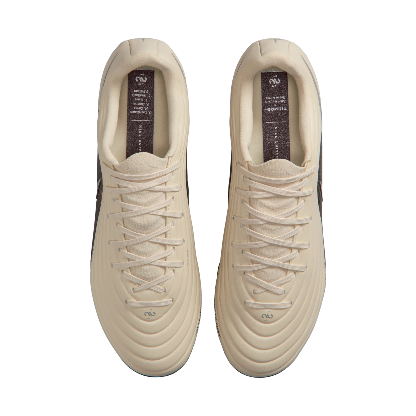 Top-down view of a pair of cream-colored Nike Tiempo soccer cleats with matching laces, displayed against a solid black background.