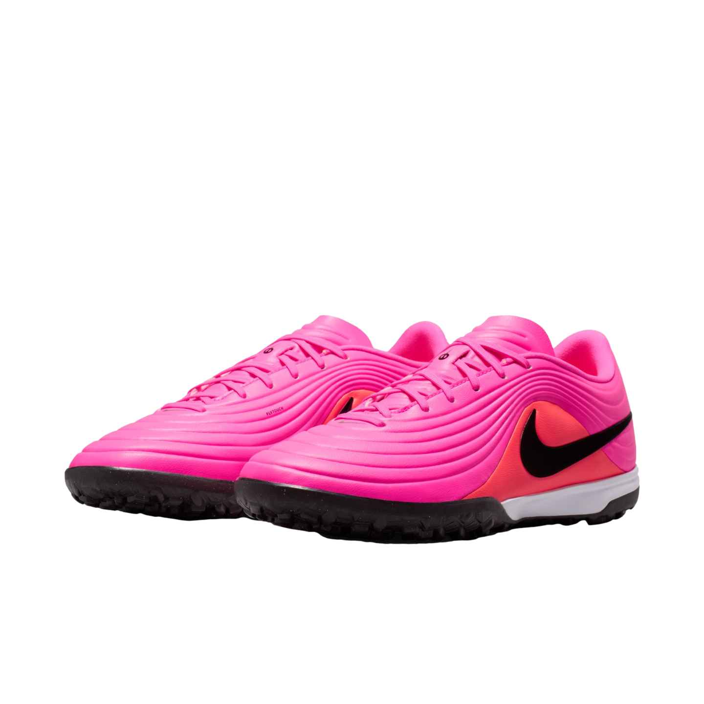 A pair of bright pink Nike turf soccer shoes featuring a textured upper, a black swoosh logo, and a black rubber outsole with traction nubs.