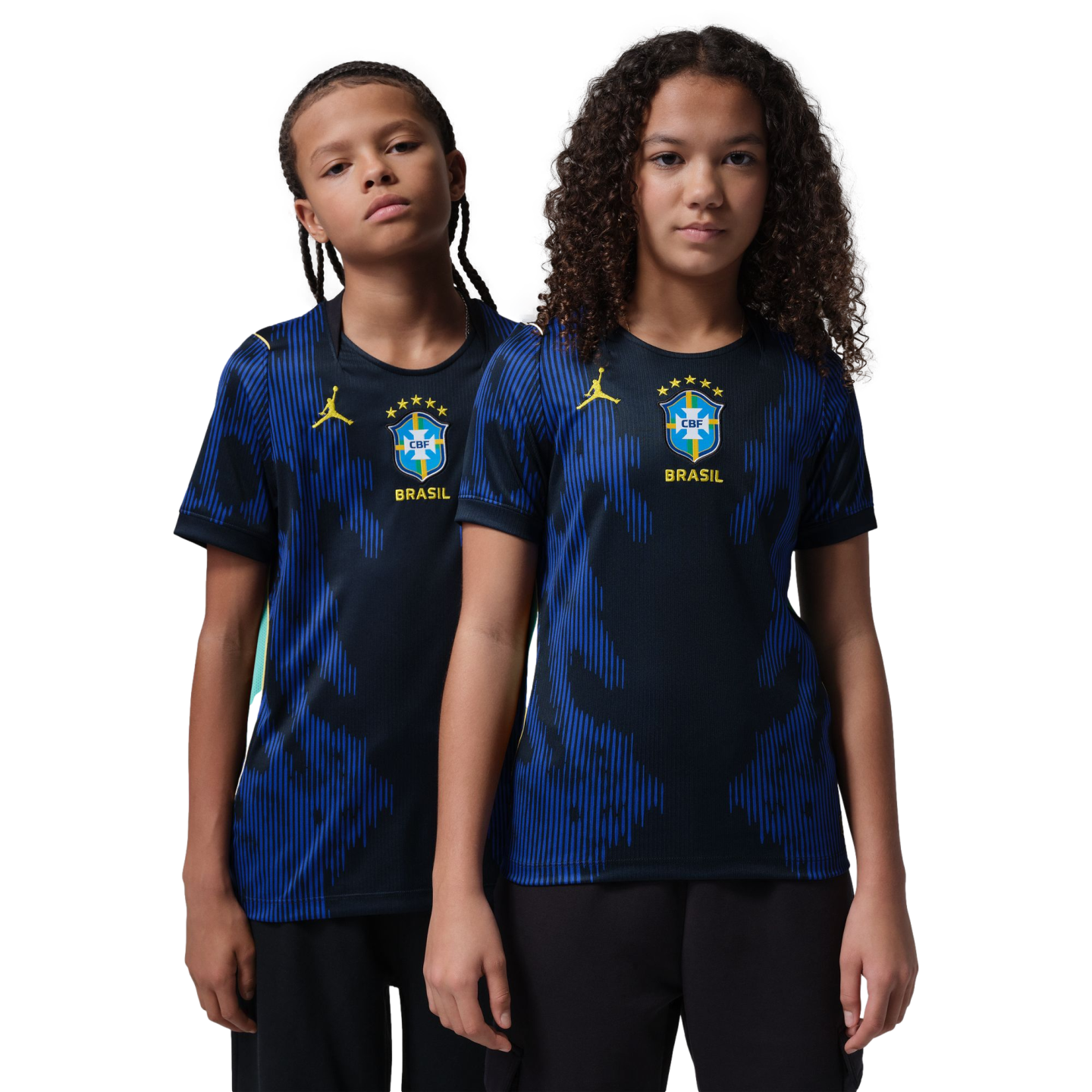 Two children pose in blue and black patterned Brazil soccer jerseys with yellow Jordan and CBF logos against a black background.