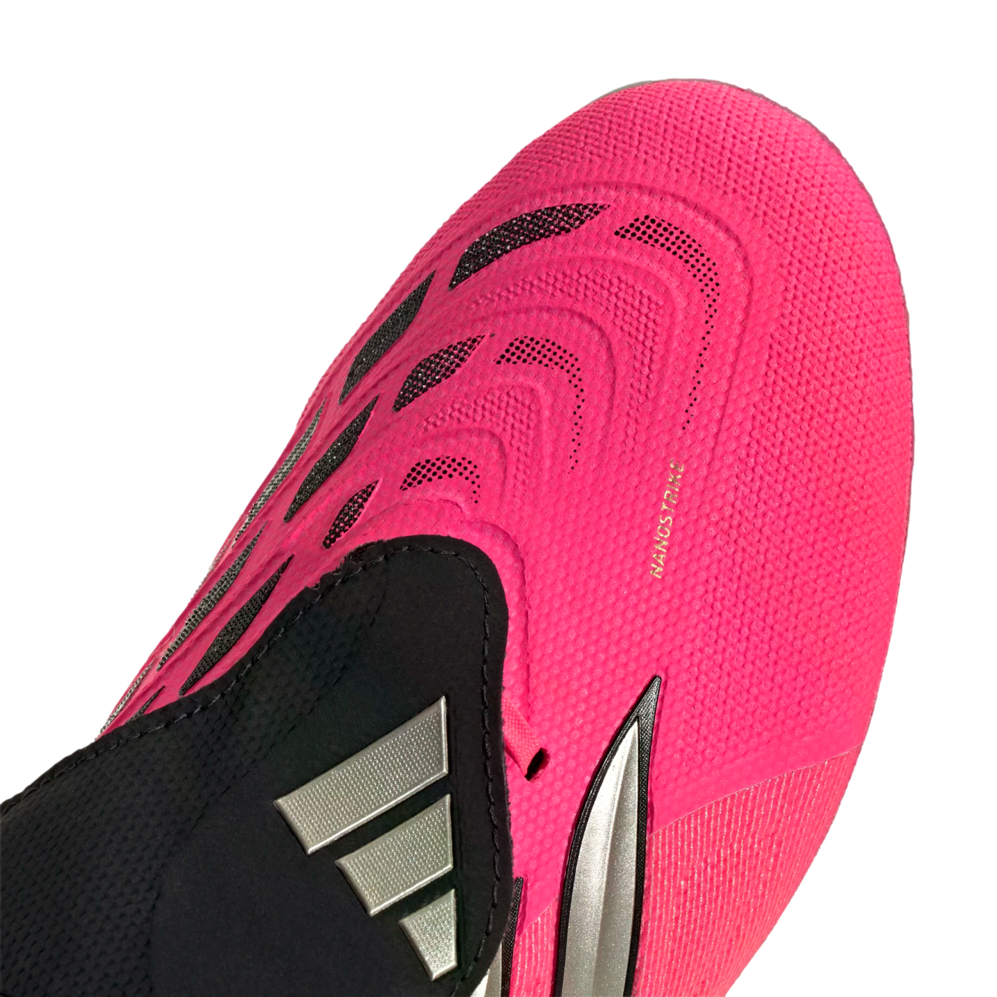 Close-up of a bright pink Adidas soccer cleat showing textured patterns, black accents, a silver logo, and 'NANOSTRIKE' lettering on the forefoot.